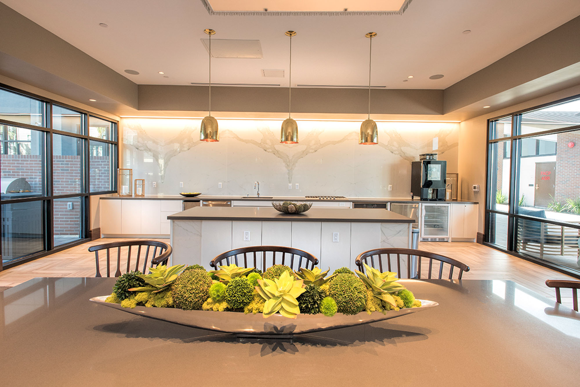 A catering open plan kitchen with an island behind a dining table at the Vintage apartments in Pleasanton, CA