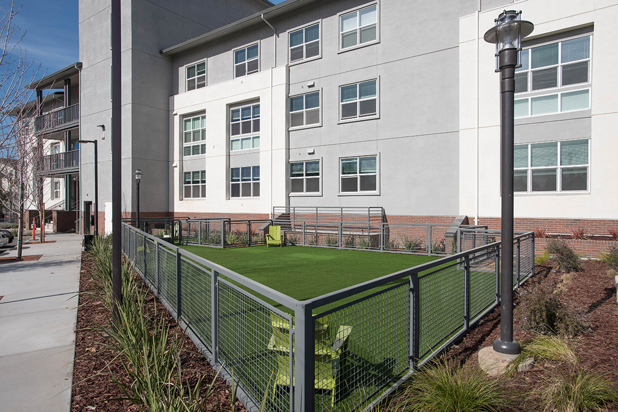 A gated dog run with outdoor lounging chairs at the Vintage apartments in Pleasanton, CA