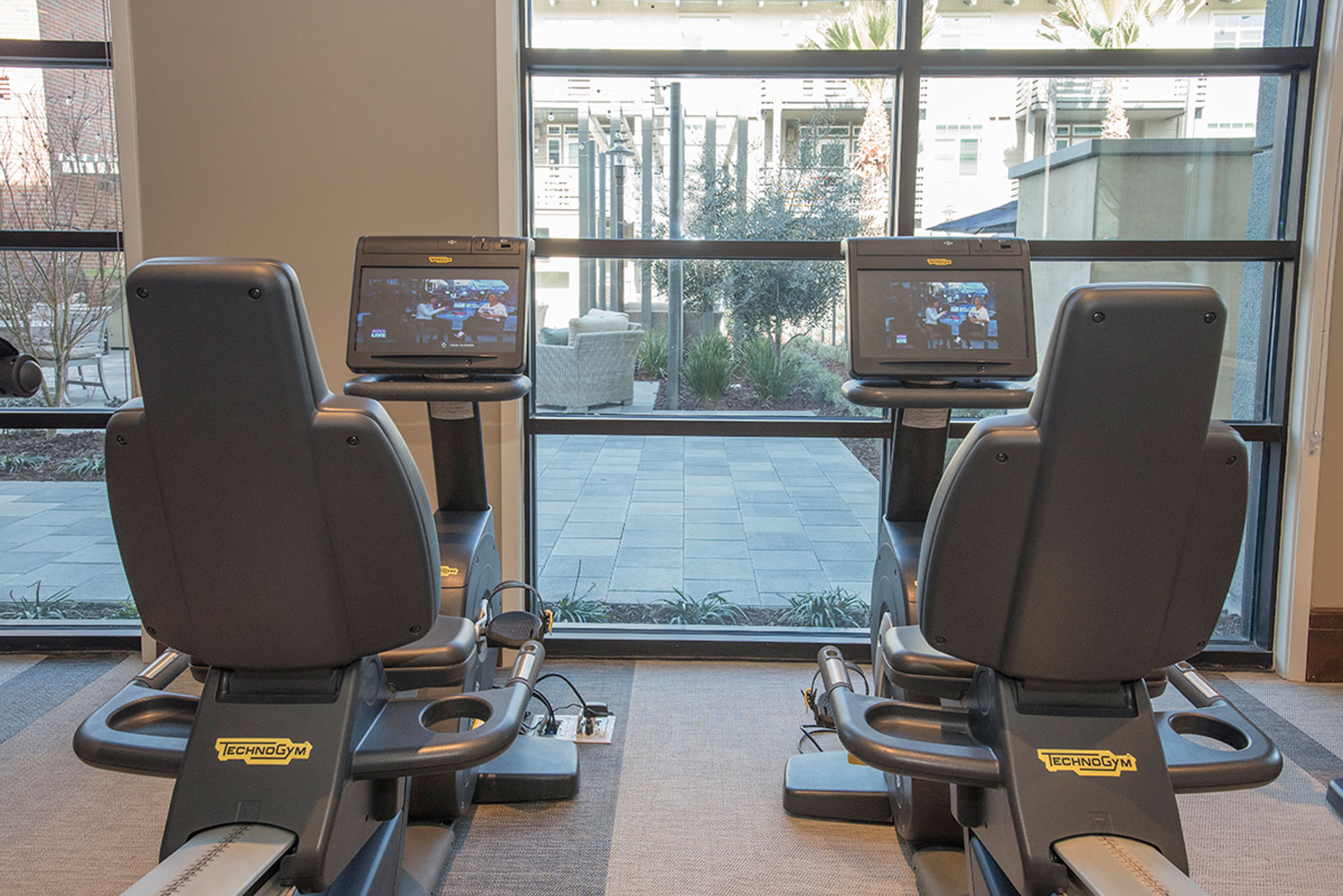 Two sitting bike machines facing the outdoor courtyard at the Vintage apartments in Pleasanton, CA