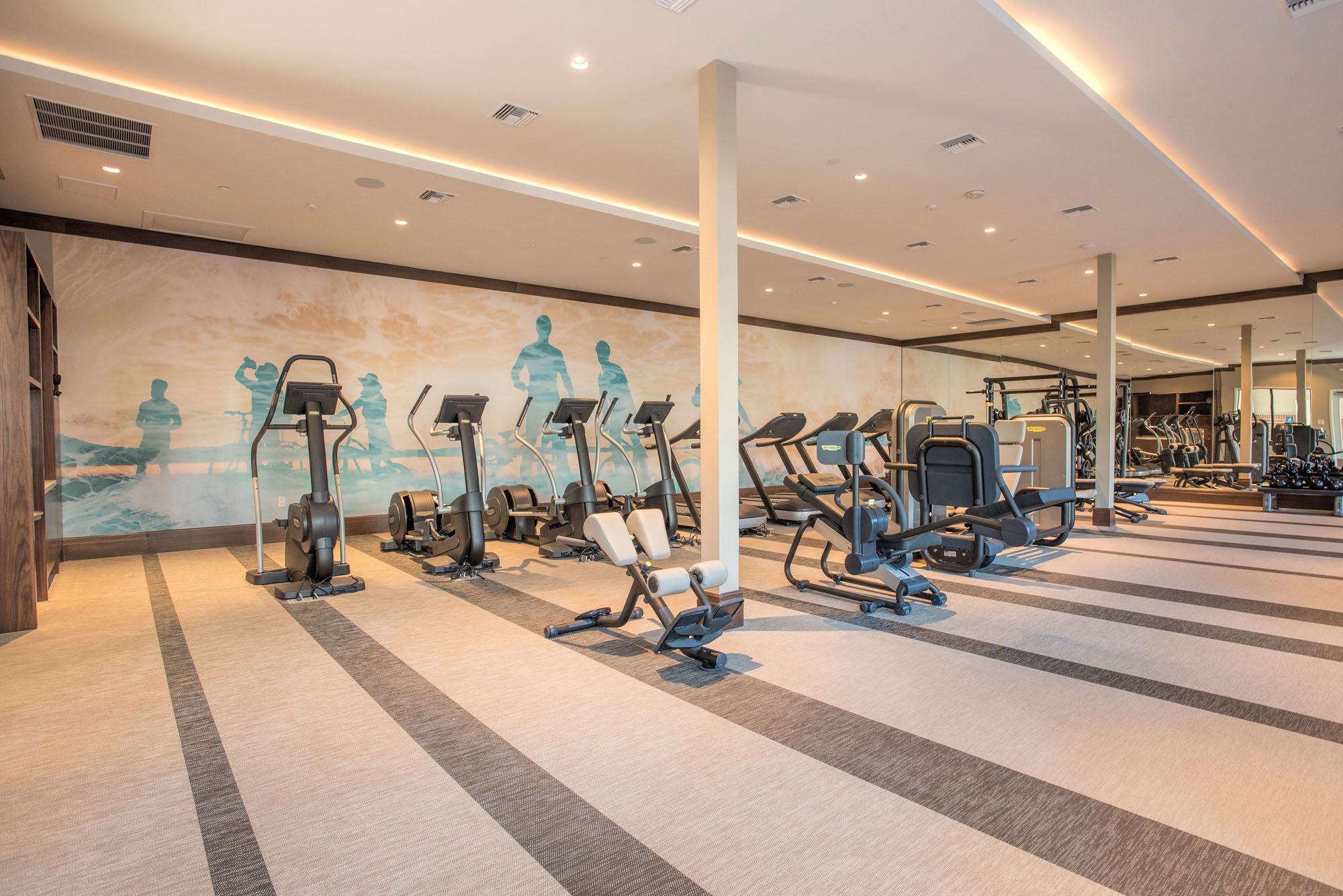 A fully equipped fitness center with benches, weight bars, cable machines and dumbbells at the Vintage apartments in Pleasanton, CA