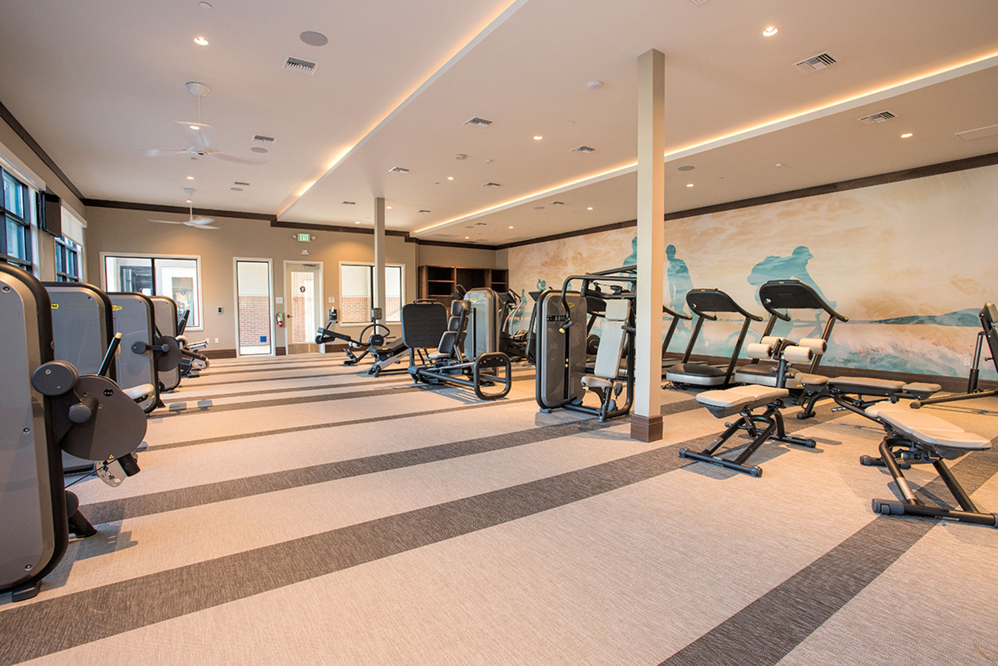 A fully equipped fitness center with benches, weight bars, cable machines and dumbbells at the Vintage apartments in Pleasanton, CA