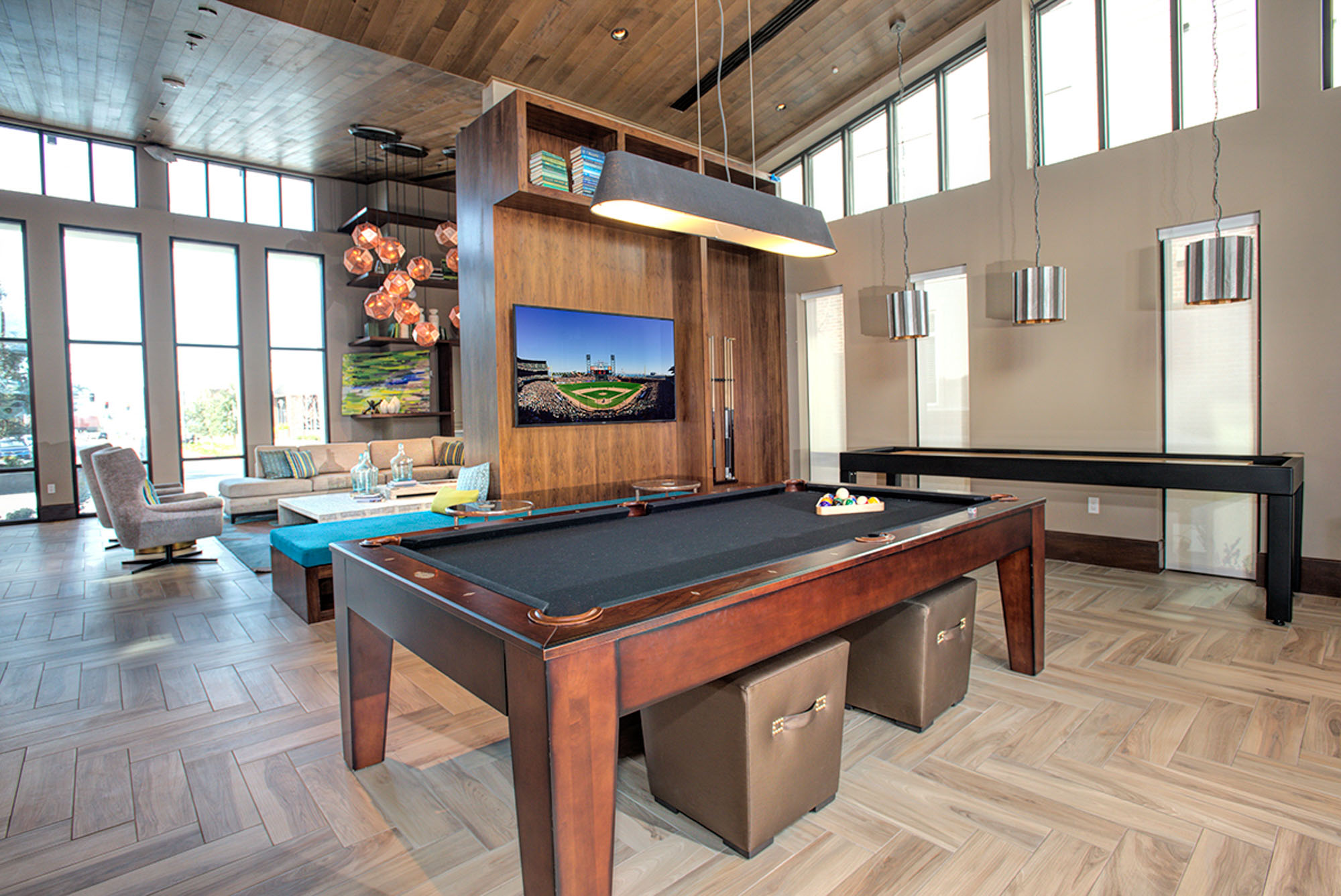 A pool table and shuffleboard in a spacious lounge in the clubhouse of the Vintage apartments in Pleasanton, CA