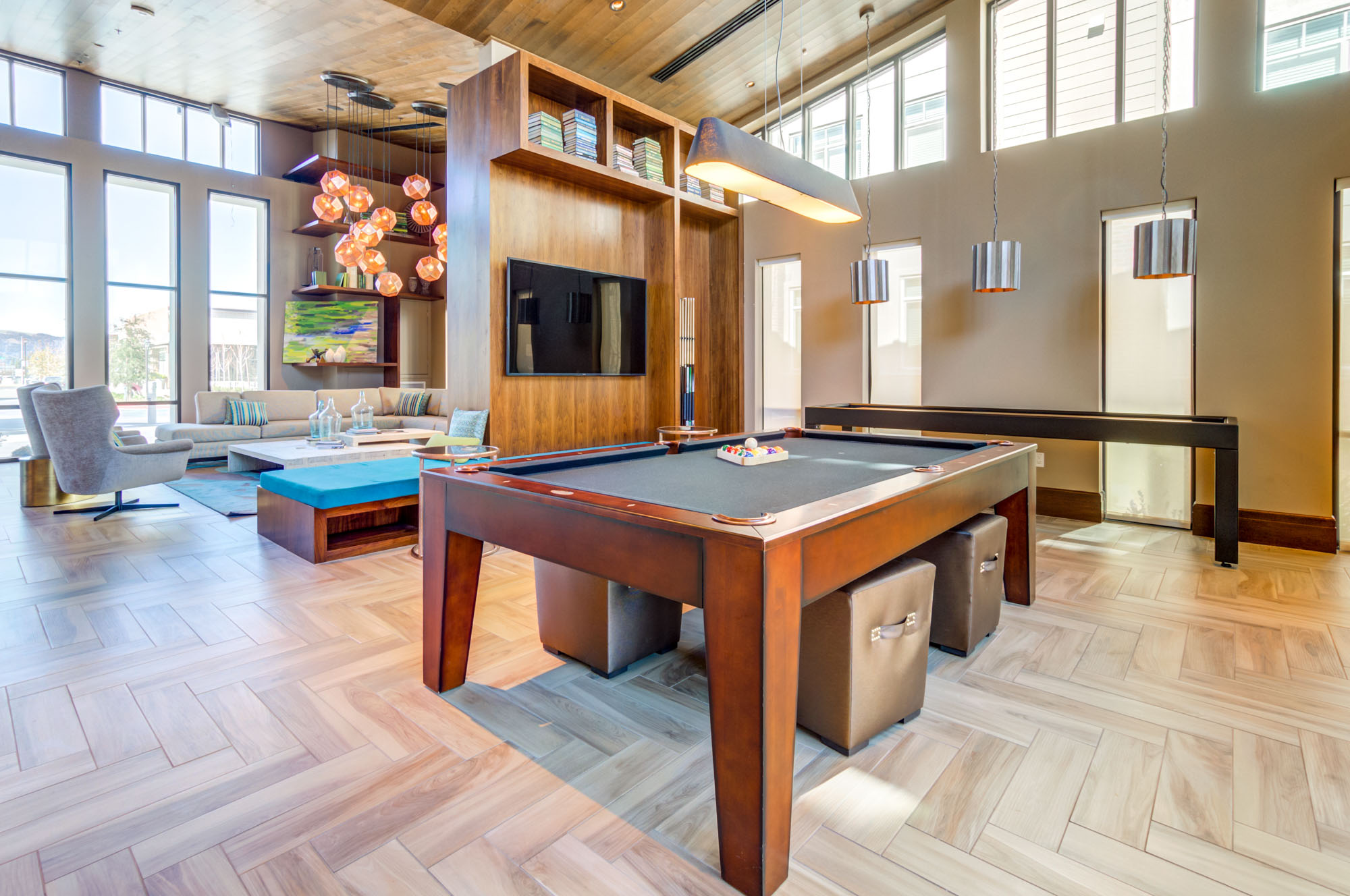 A pool table and shuffleboard in a spacious lounge in the clubhouse of the Vintage apartments in Pleasanton, CA