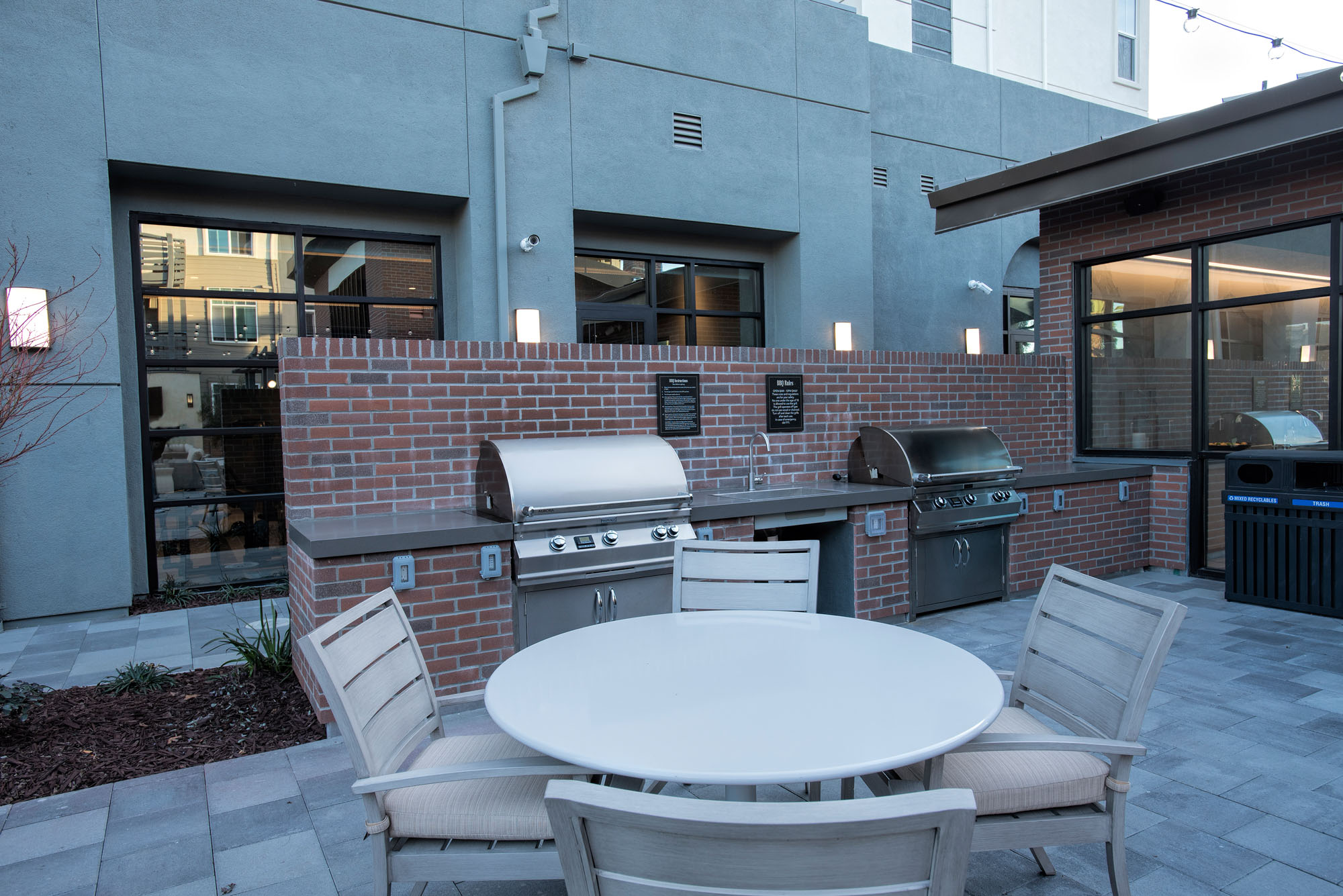 An outdoor grilling station with a dining table, at the Vintage apartments in Pleasanton, CA