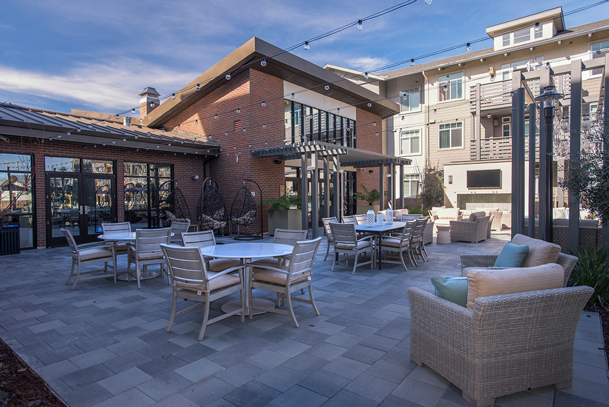 An outdoor lounging area with several dining tables at the Vintage apartments in Pleasanton, CA