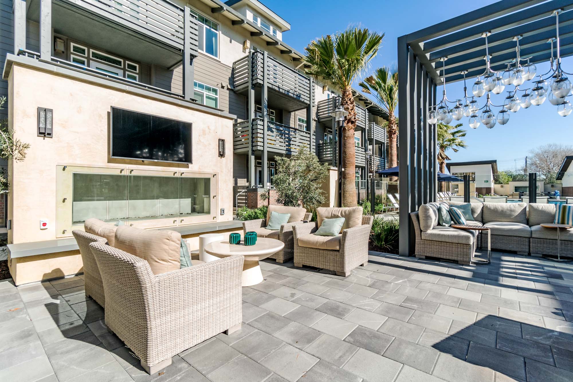 A lounge with a fireplace and TV at the outdoor terrace of the Vintage luxury apartments in Pleasanton, CA