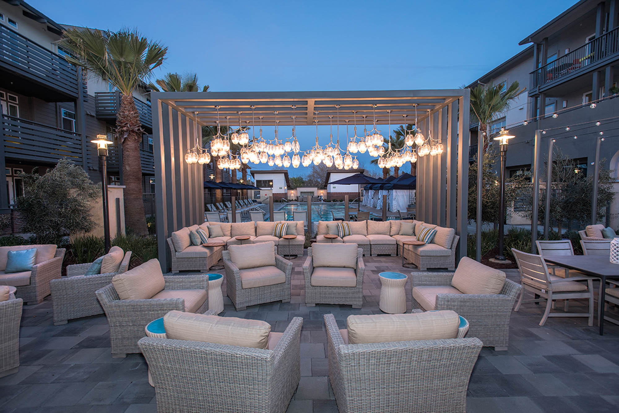 An outdoor terrace with several seating areas and dining tables at Vintage apartments in Pleasanton, CA