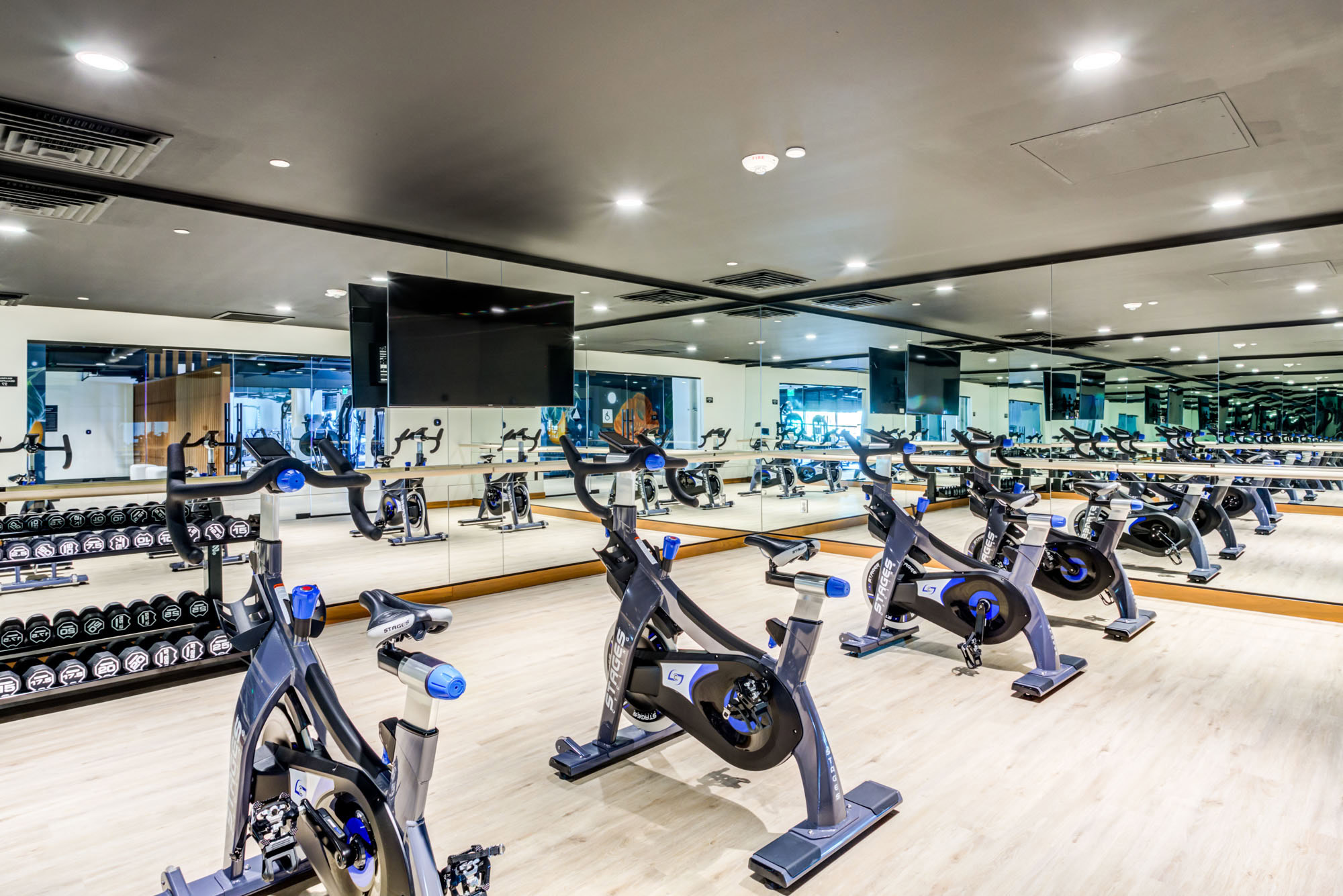A cycling studio with mirror walls and a TV at the Webster Eleven apartments in downtown Oakland