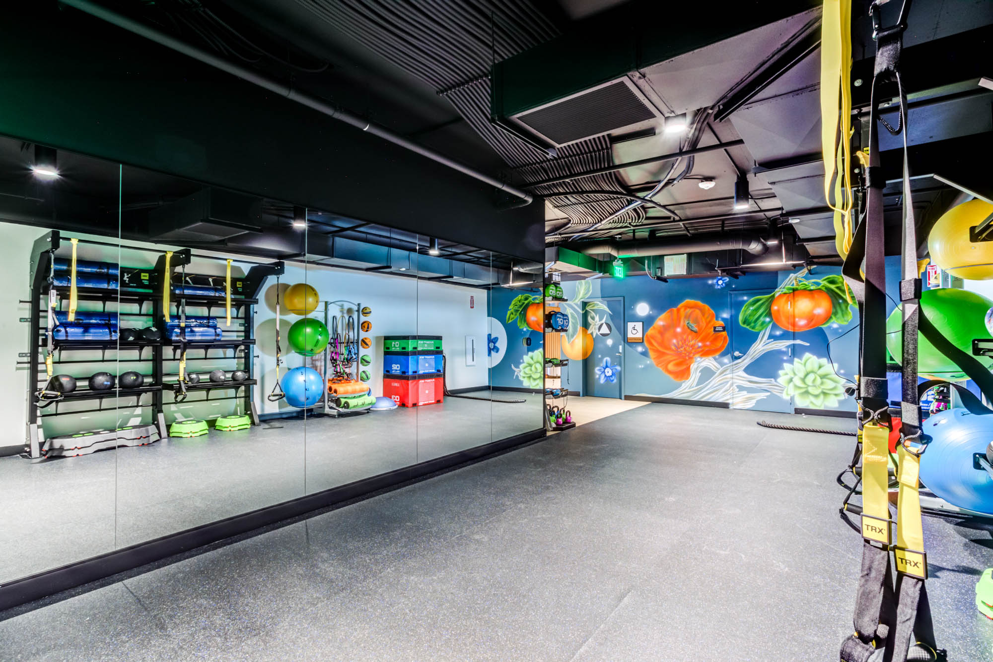 A fitness studio with a graffiti and mirror wall at the Webster Elevens downtown Oakland apartments for rent