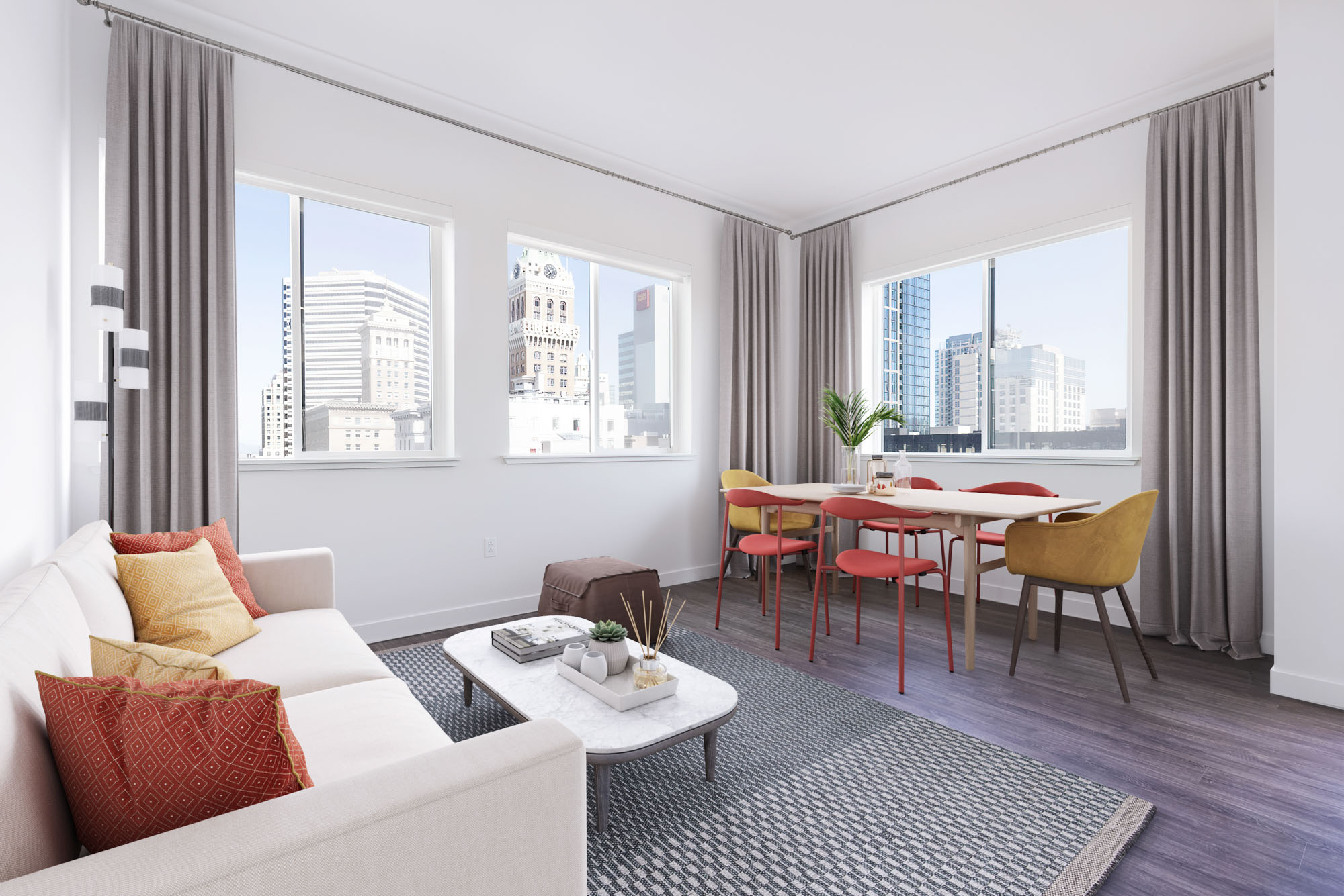 A modern living room and dining area with 3 large windows showing city views at the Webster Eleven apartments in downtown Oakland