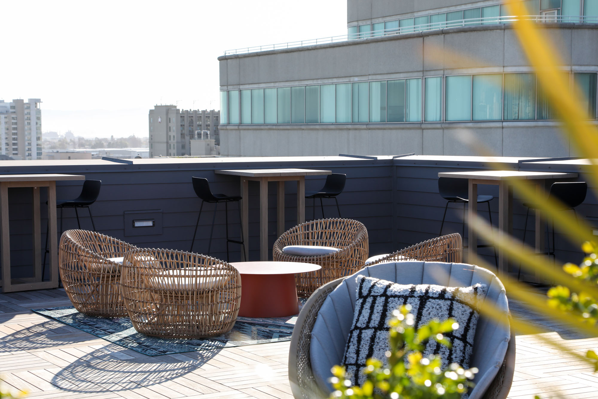 A rooftop lounge with chairs and high tables at the Webster Eleven apartments in downtown Oakland
