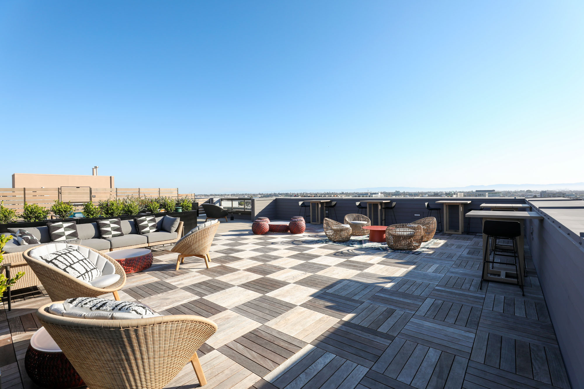 A rooftop lounge with seating and high tables and chairs at the Webster Eleven apartments in downtown Oakland