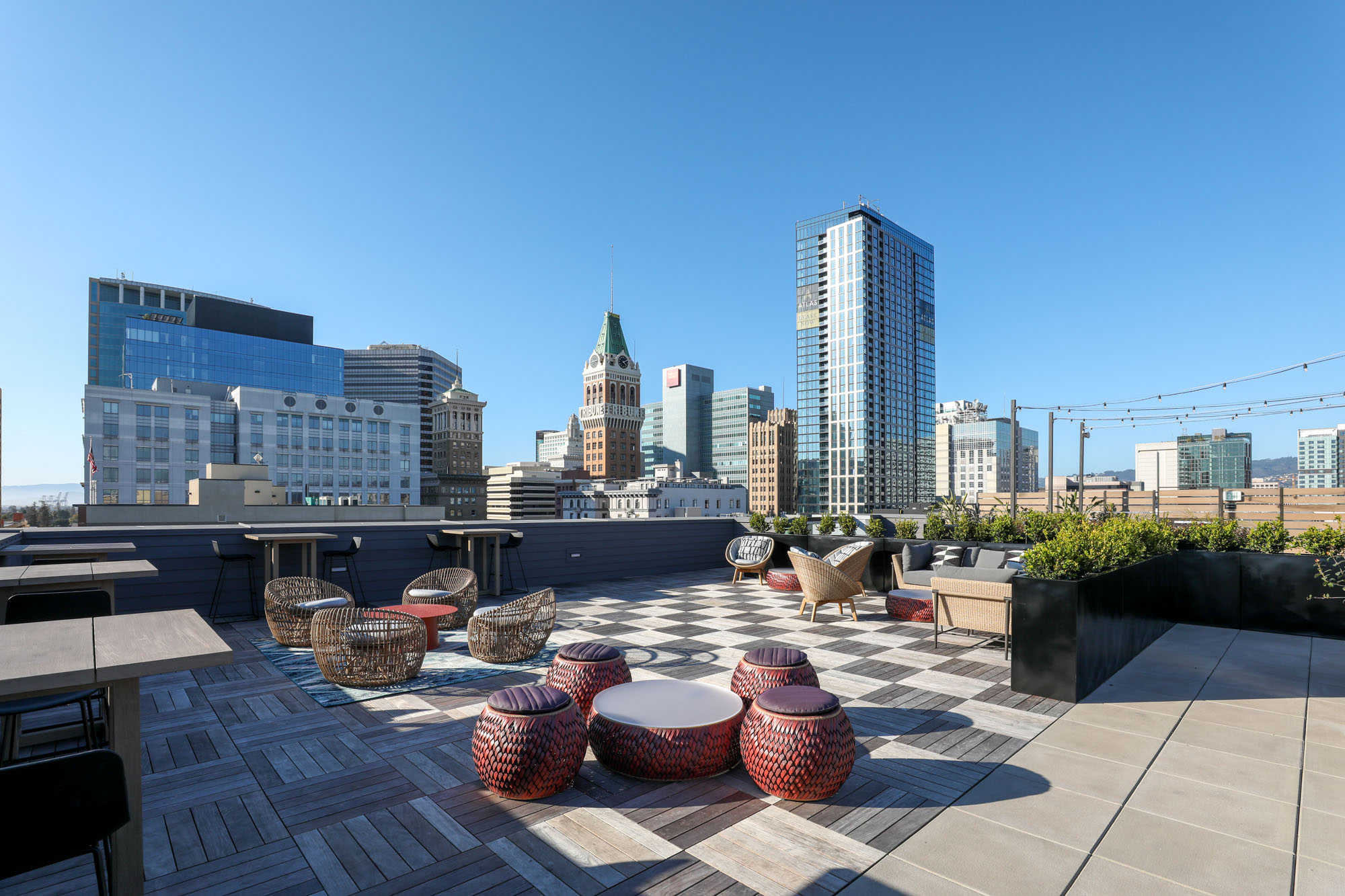 A rooftop lounge with seating and high tables and chairs at the Webster Eleven apartments in downtown Oakland
