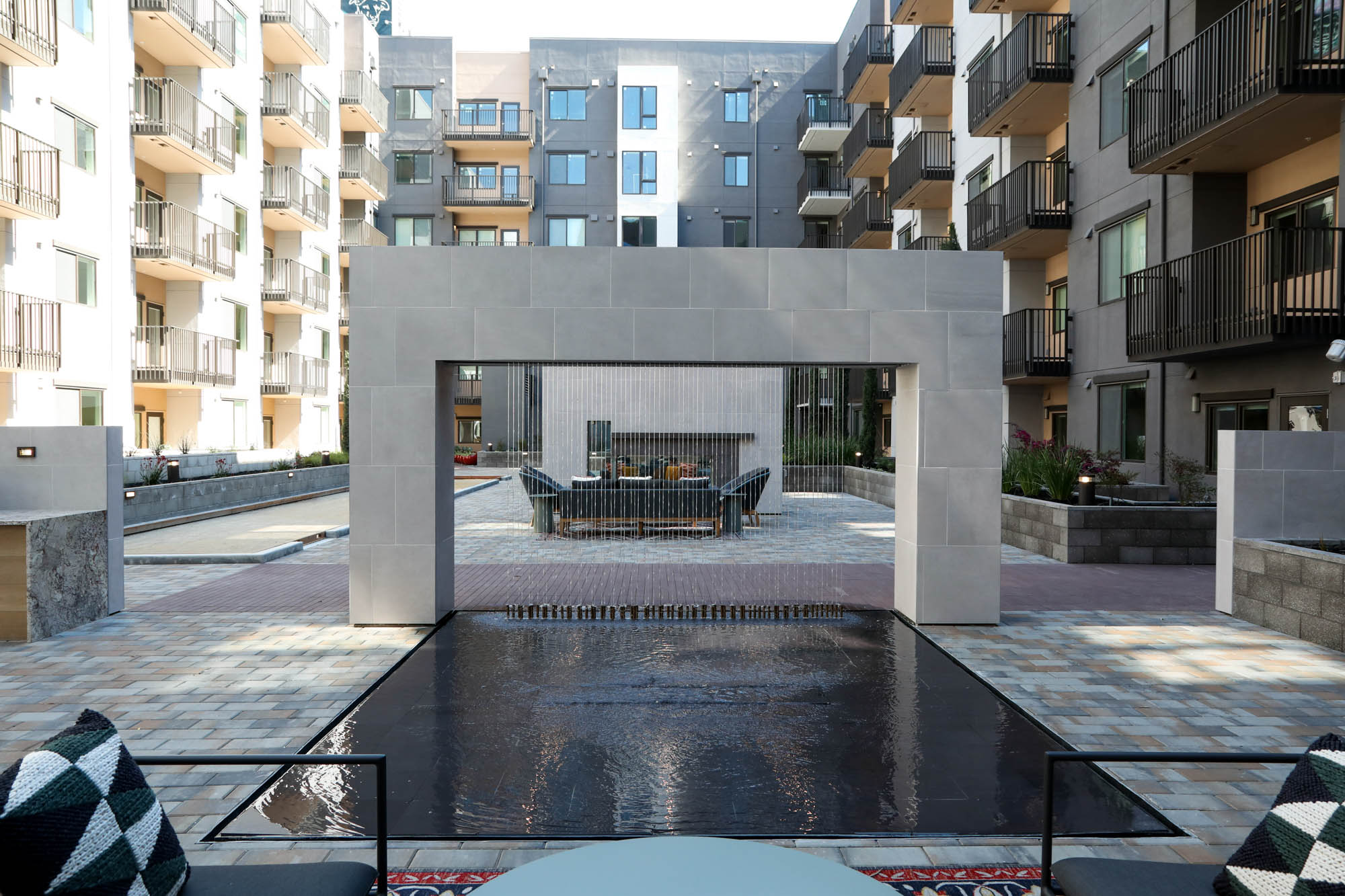 A modern courtyard fountain with lounging chairs at Webster Eleven in downtown Oakland