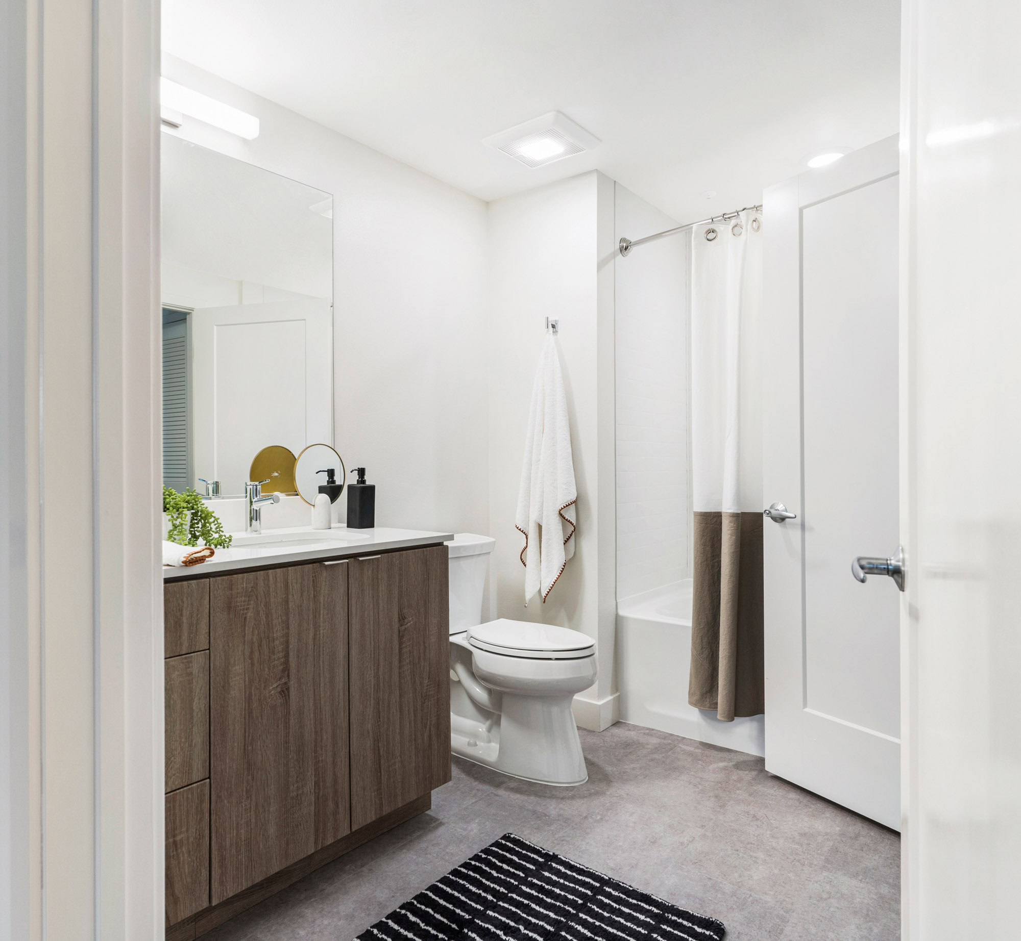 A bathroom with a tub and shower head at the Webster Elevens downtown Oakland apartments for rent