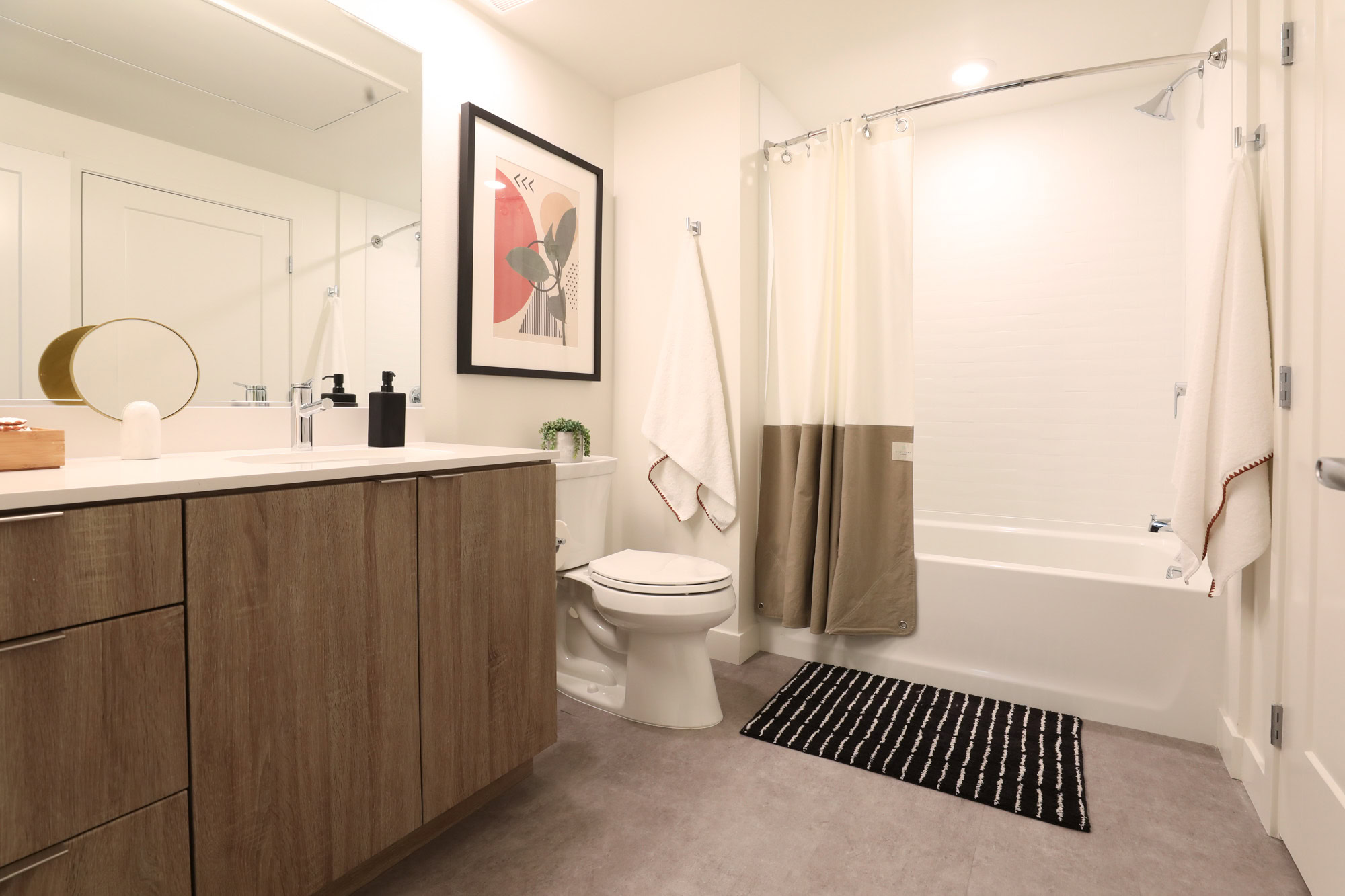 A bathroom with a tub and shower head at the Webster Elevens downtown Oakland apartments for rent