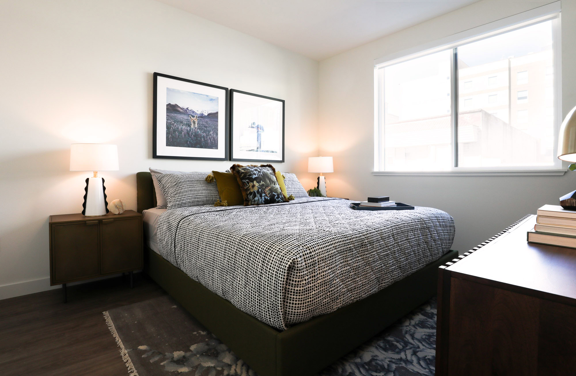 A bedroom with hardwood floors and windows at the Webster Eleven downtown Oakland apartments for rent