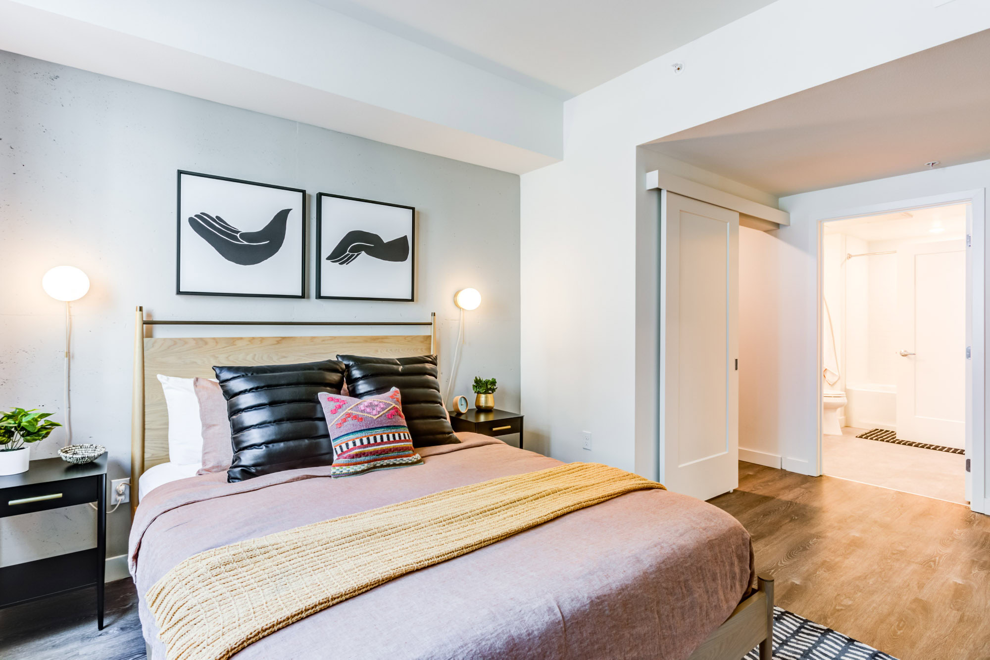 A bedroom with a walk-in closet and an ensuite bathroom at the Webster Eleven apartments in downtown Oakland