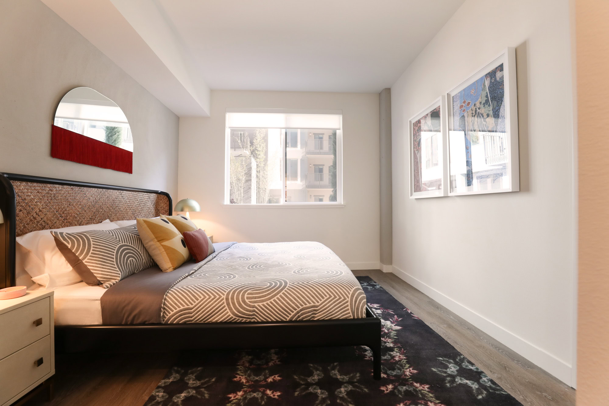 A bedroom with hardwood floors and a window at the Webster Eleven downtown Oakland apartment for rent