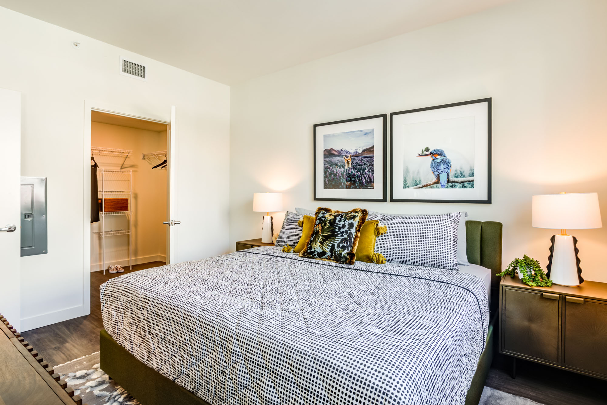 A bedroom with hardwood floors and a walk in closet at the Webster Eleven downtown Oakland apartment for rent