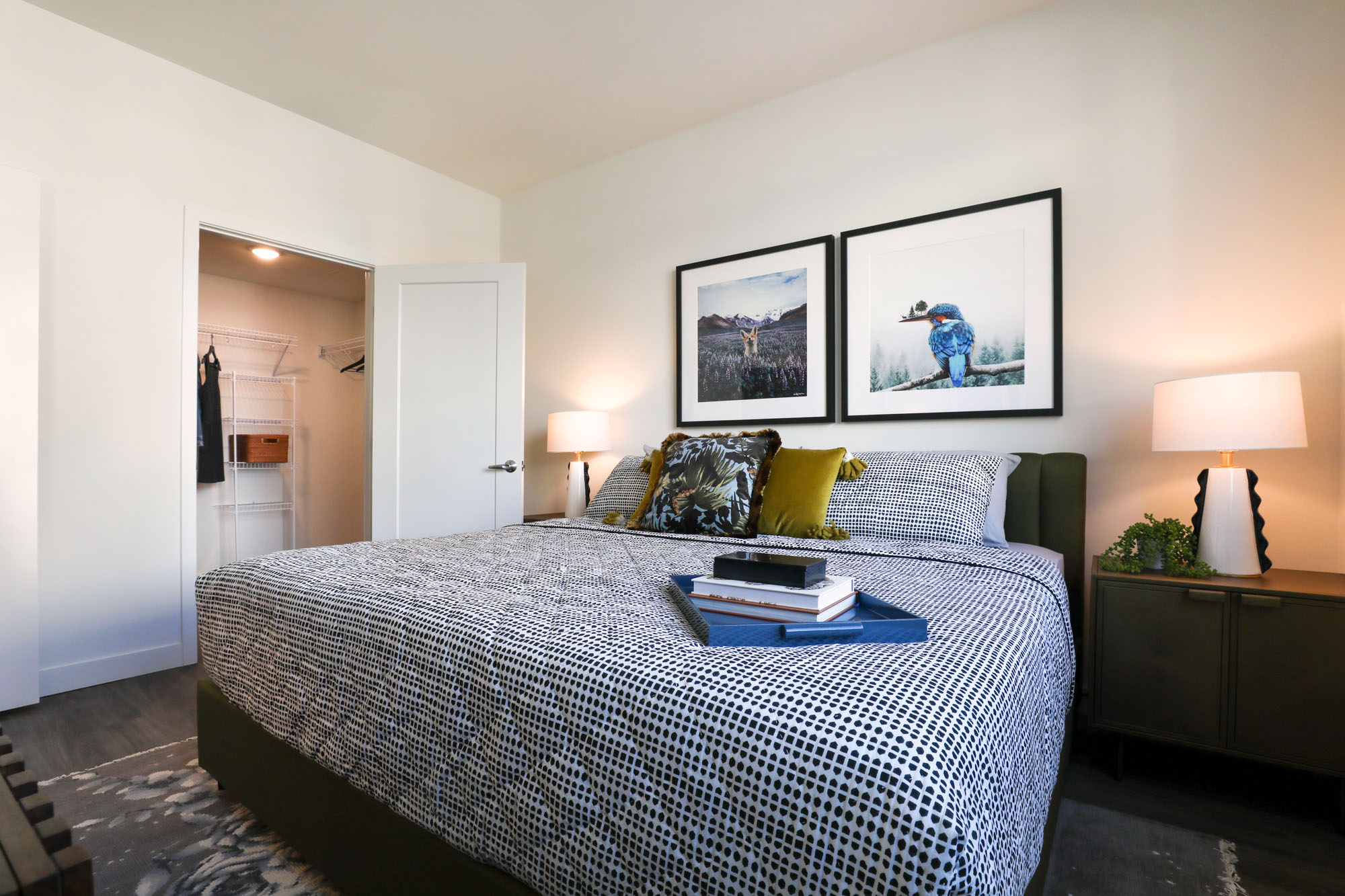 A bedroom with hardwood floors and a walk in closet at the Webster Eleven downtown Oakland apartment for rent