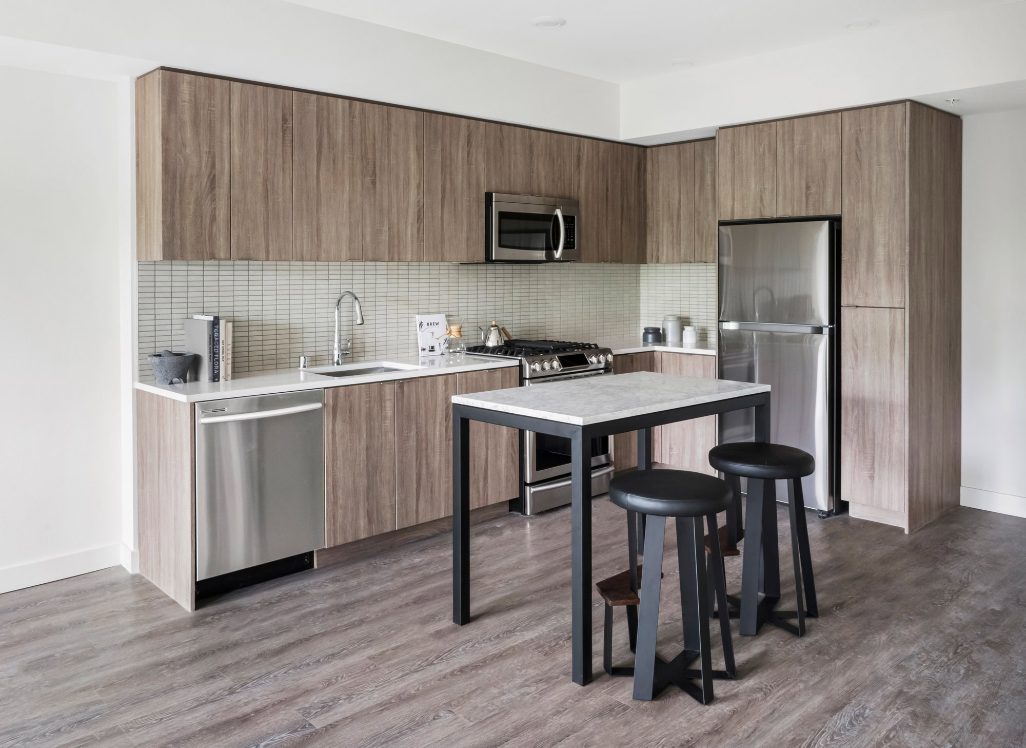 A kitchen with a kitchen island at the Webster Elevens downtown Oakland apartments for rent