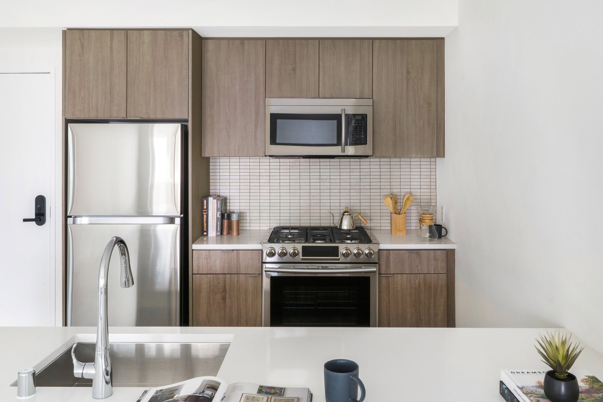 A kitchen with white quartz counters at the Webster Elevens downtown Oakland apartments for rent