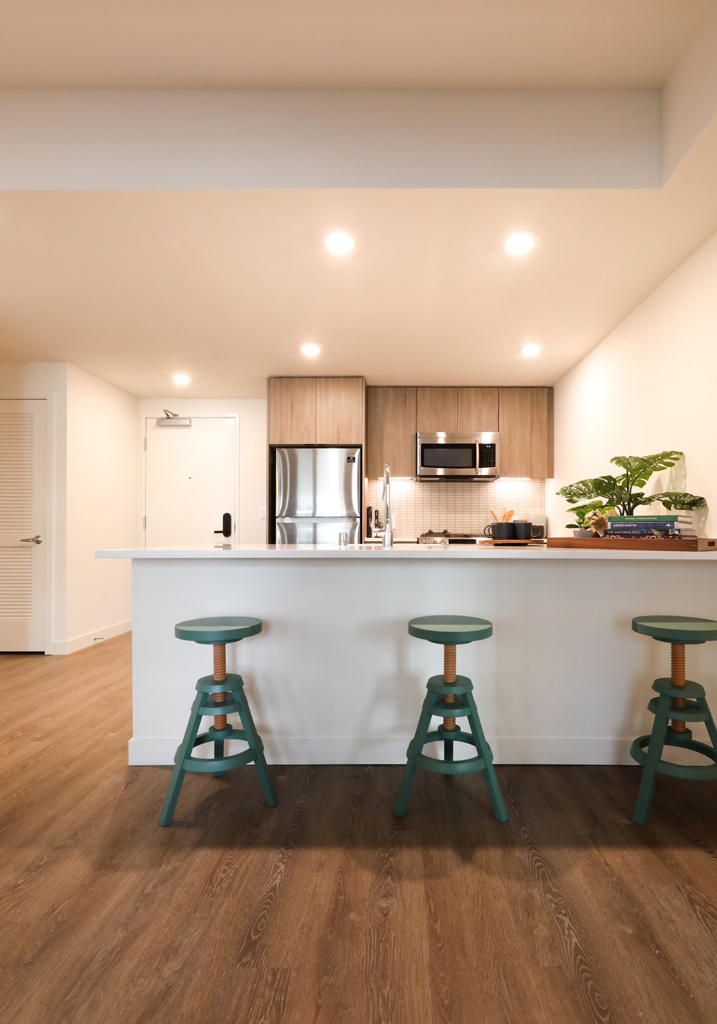 A kitchen with a peninsula and hardwood floors at the Webster Eleven downtown Oakland luxury apartments 