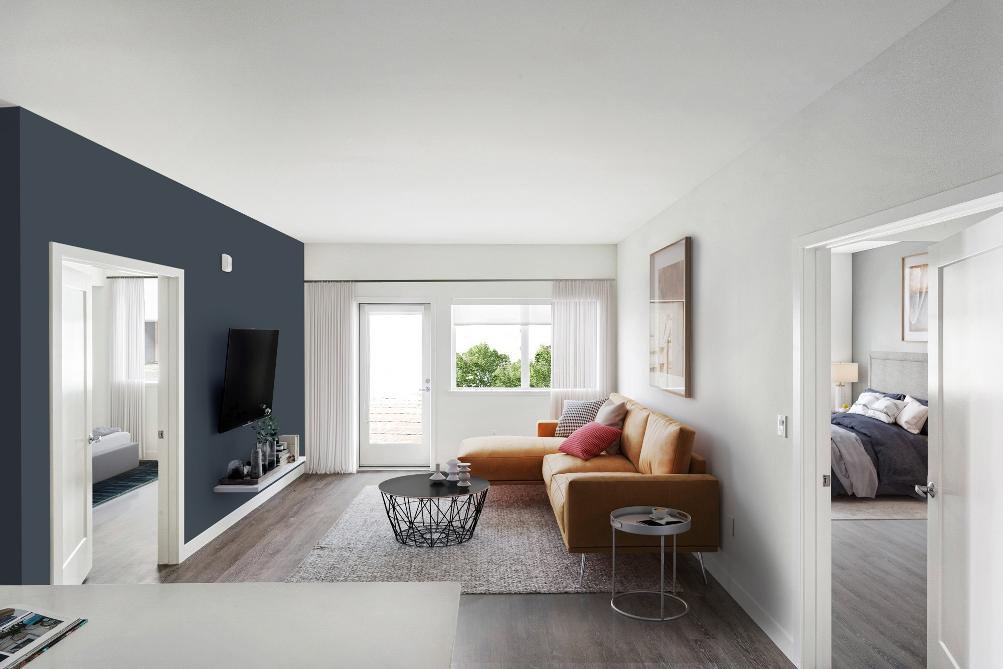 A living area with two doors on either side of two opposite walls leading to bedrooms at the Webster Eleven apartments in downtown Oakland