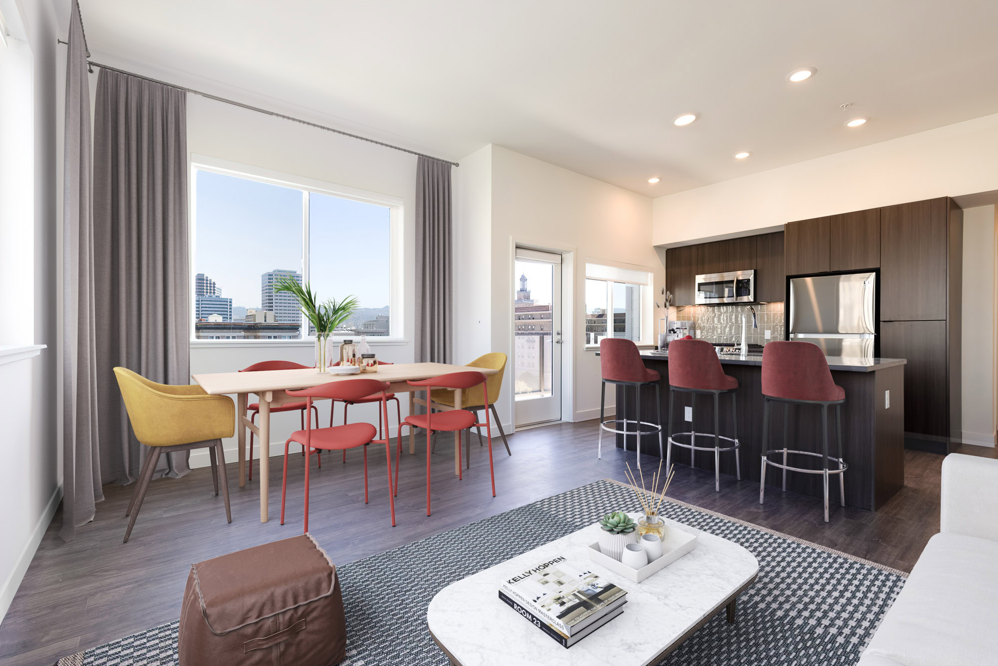 A luxurious apartment dining area with a kitchen featuring a kitchen island at the Webster Eleven apartments in downtown Oakland