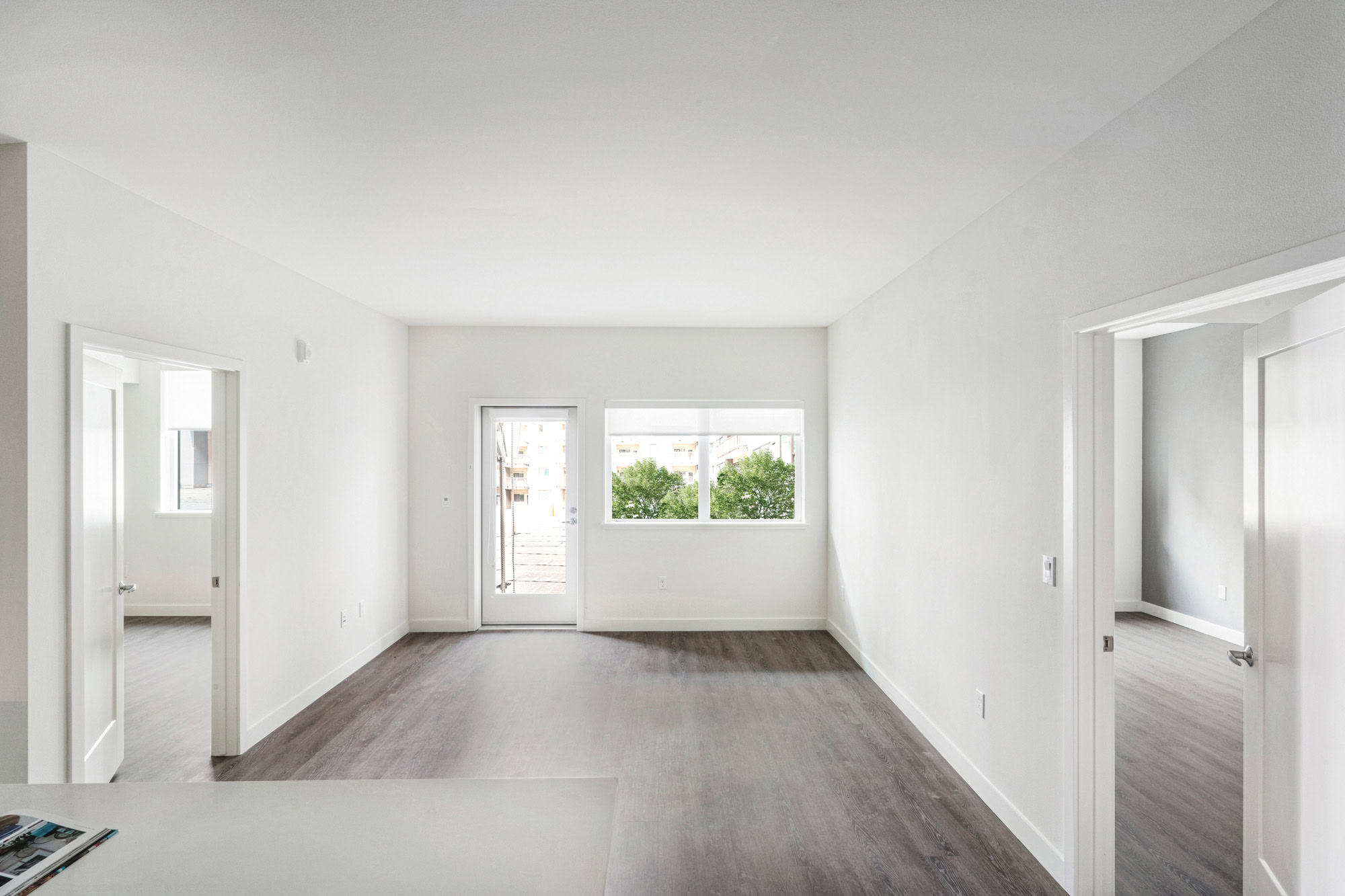 A living area with two doors on either side of two opposite walls leading to bedrooms at the Webster Eleven apartments in downtown Oakland