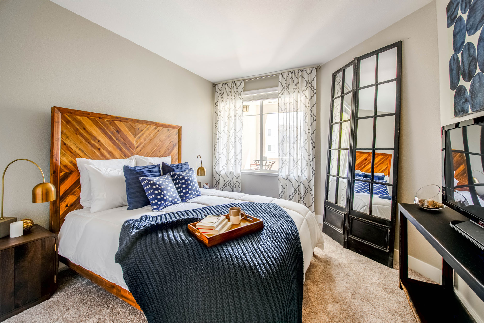 A cozy bedroom with carpet flooring at Alders luxury apartments in Northridge, Los Angeles