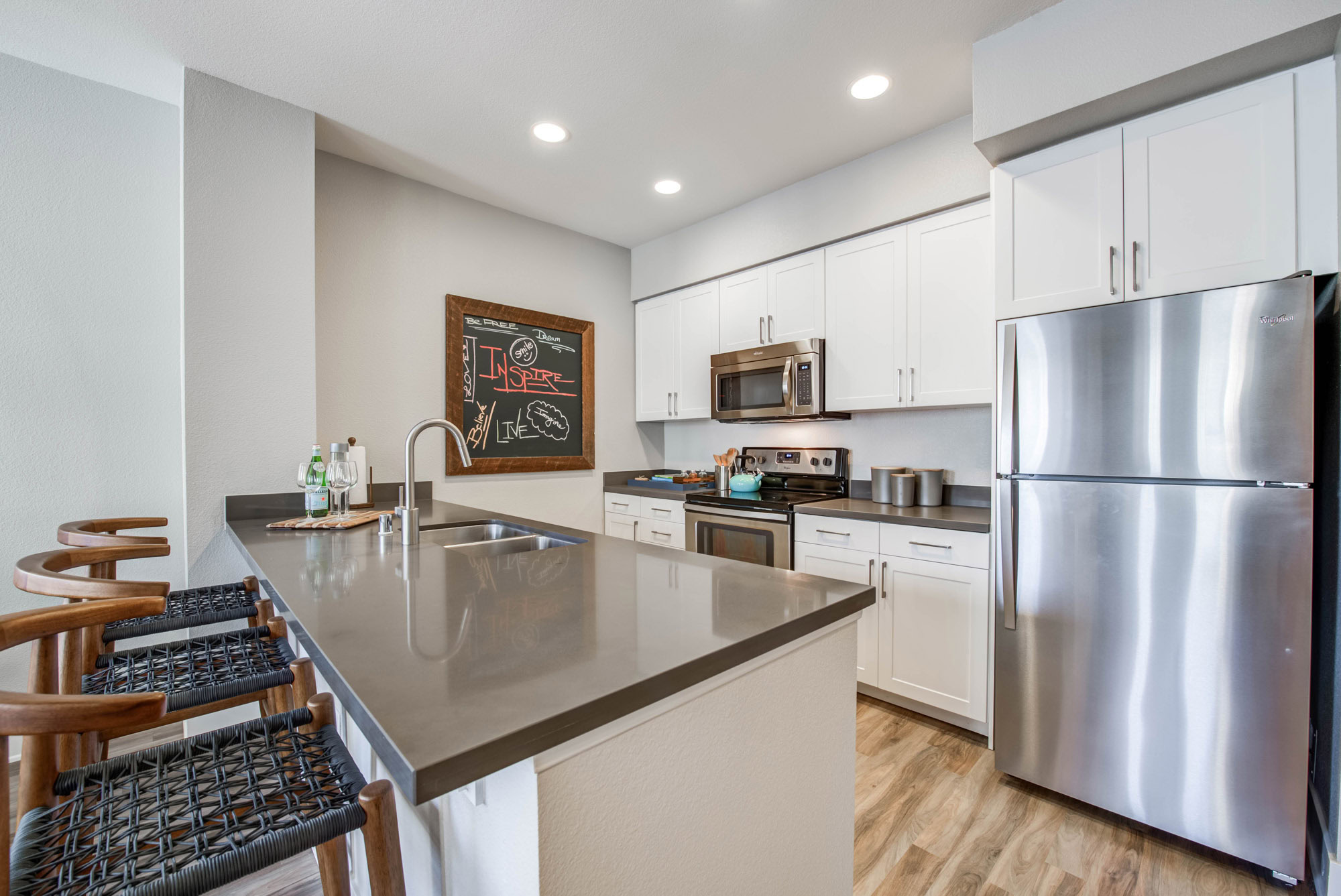 A modern kitchen with a kitchen island and stainless steel appliances at Adlers luxury apartments in Northridge CA