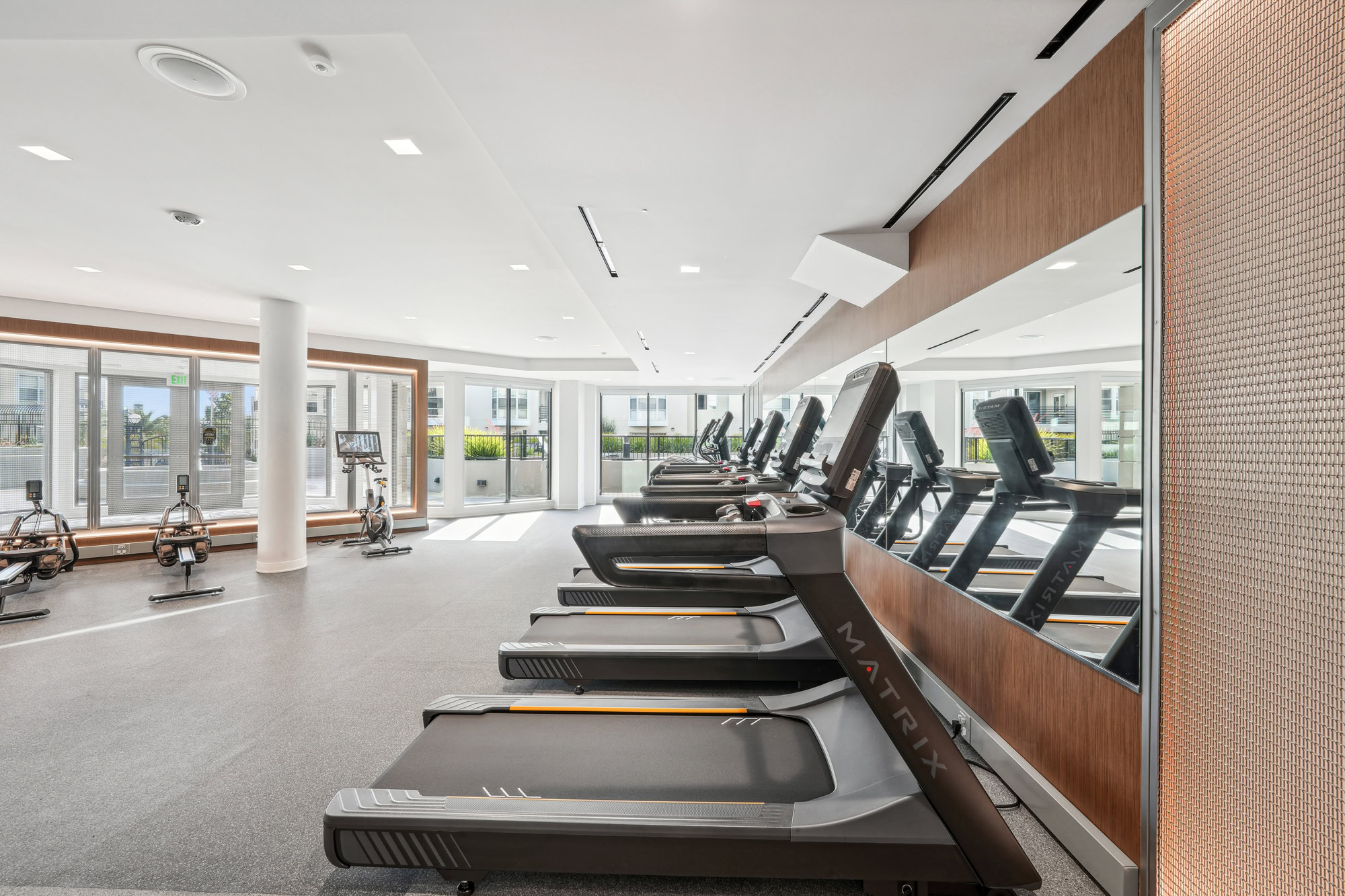 A spacious fitness center with treadmills, cycling and rowing machines, at Bayside Villages modern apartments in downtown San Francisco