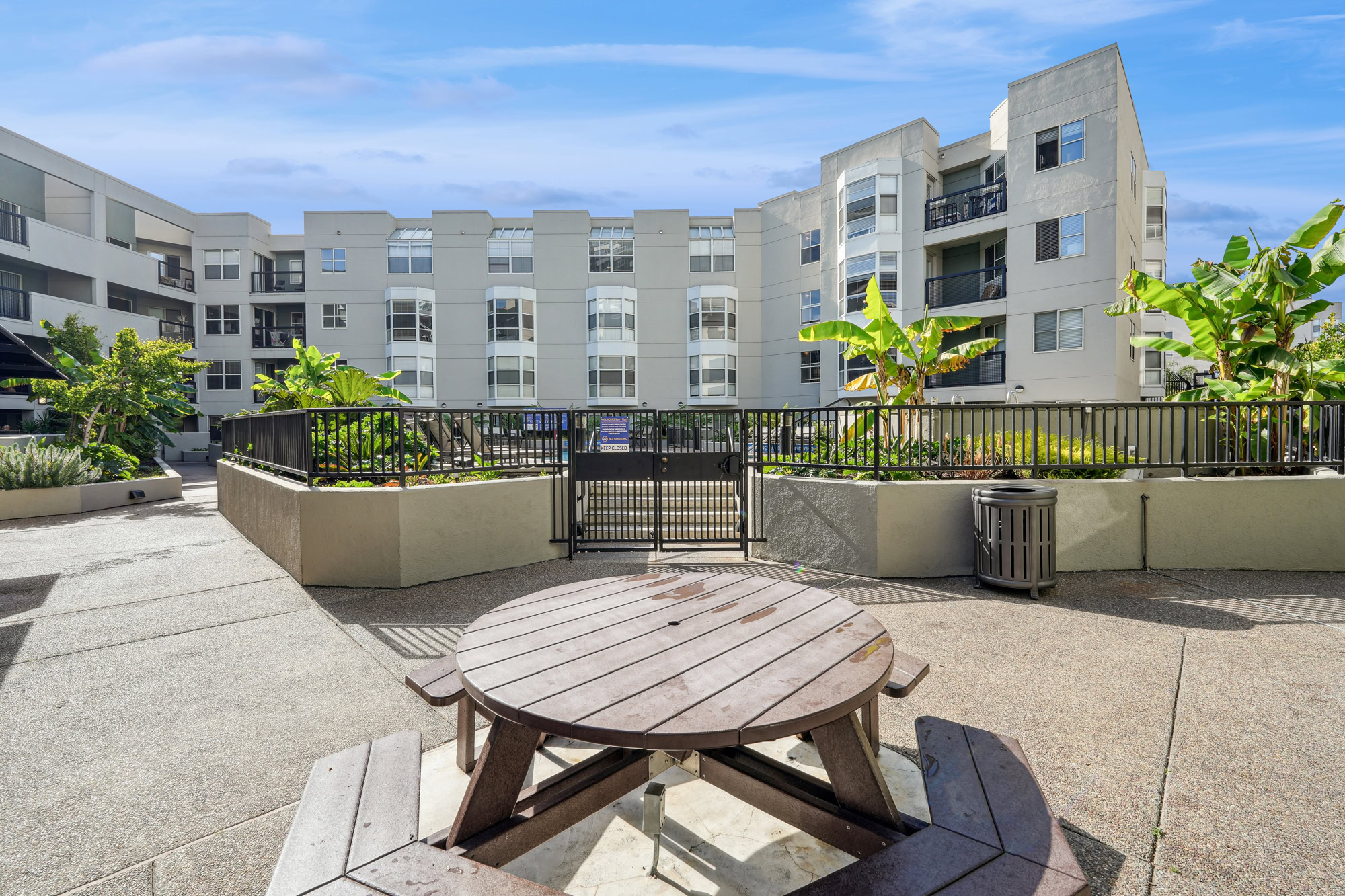 A picnic table in front of a gated pool area at the Bayside Village apartments in San Francisco