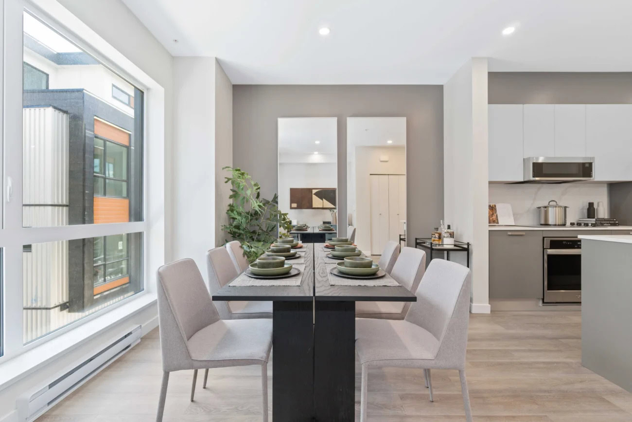 A spacious dining area next to a large window at the Hendry Place luxury apartments in Vancouver