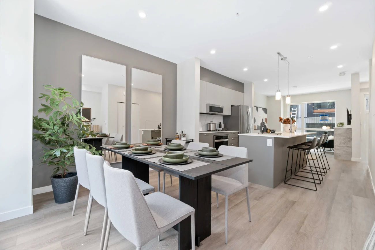 A spacious dining area next to a kitchen with a kitchen island at the Hendry Place luxury apartments in Vancouver