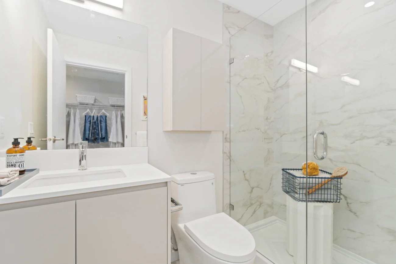 A bathroom with a standing shower next to the walk-in closet at the Hendry Place apartments in Vancouver