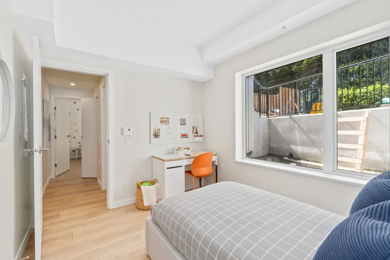 A childs bedroom with a large window at the Hendry Place luxury apartments in Vancouver