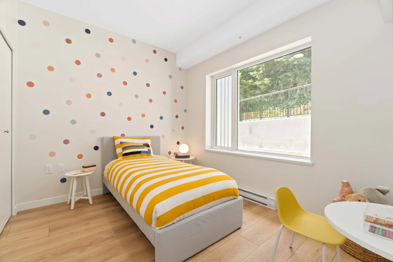 A childs bedroom with a large window at the Hendry Place luxury apartments in Vancouver