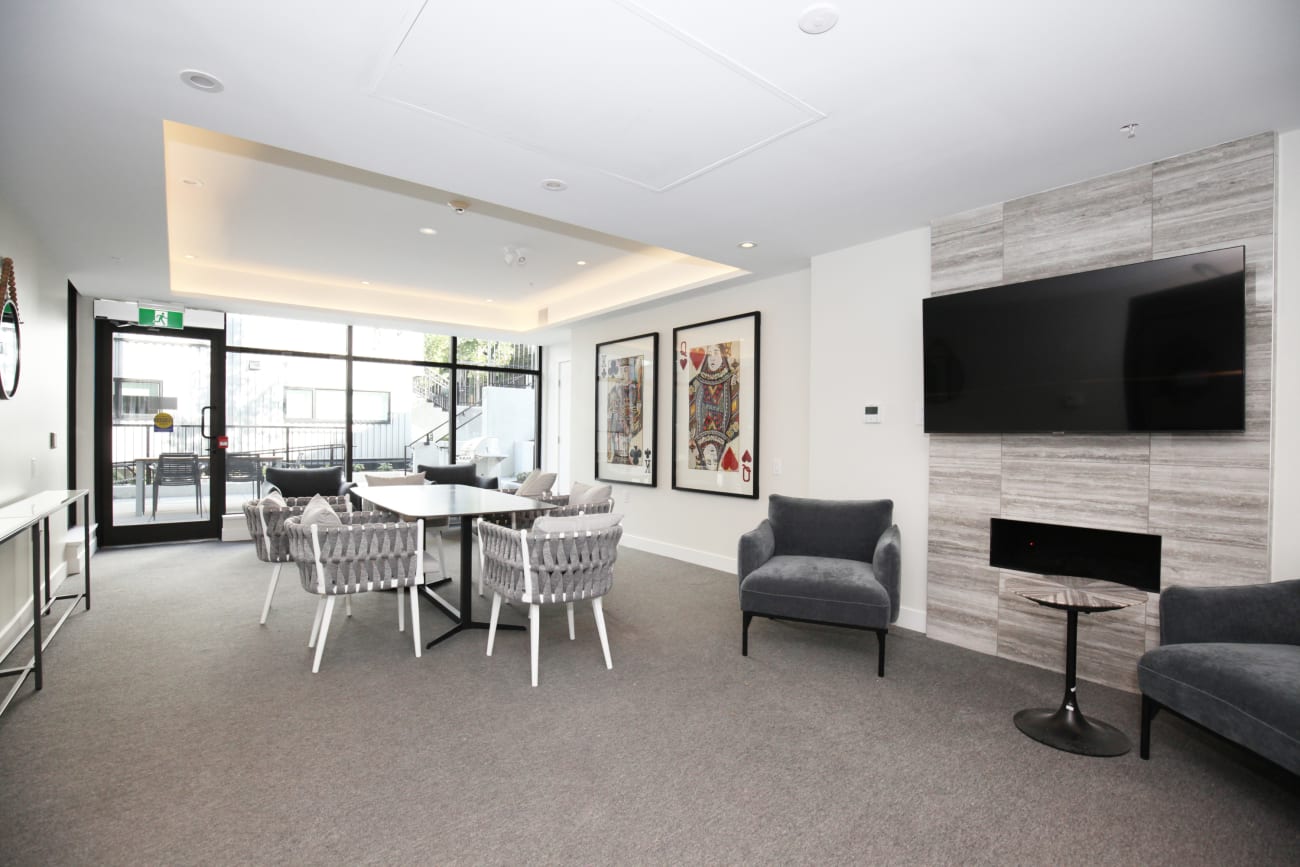 A lounge featuring dining tables and a TV at the Hendry Place pet-friendly apartments in Vancouver BC