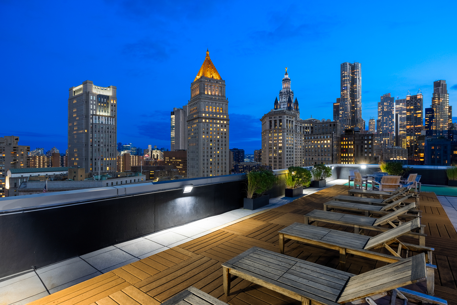 Sky Deck with panoramic vistas and lounge chairs at night.