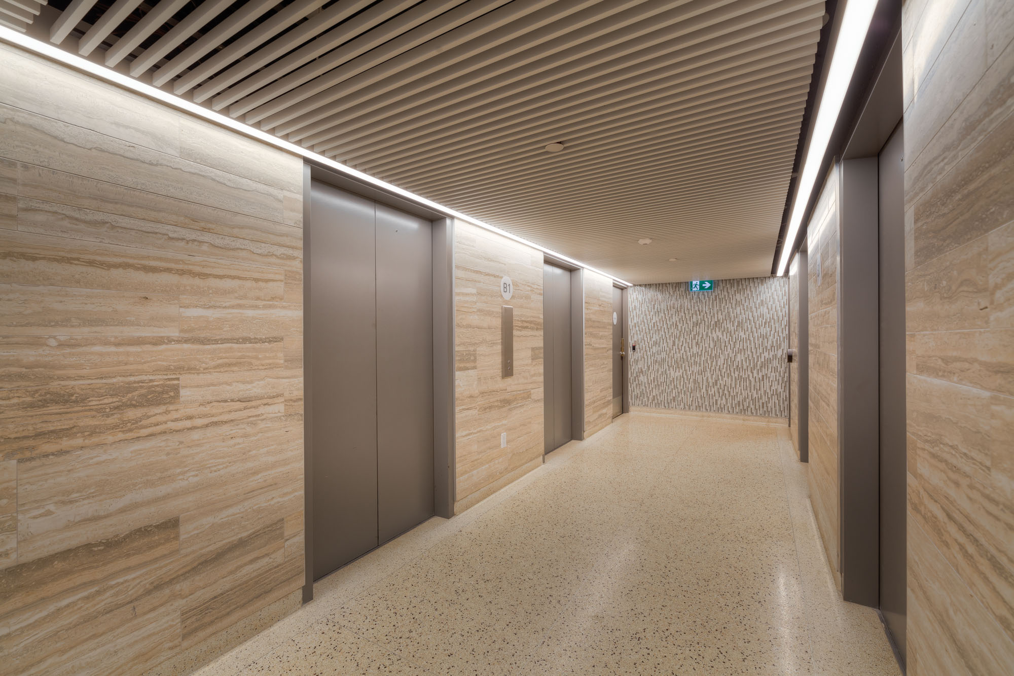 A hallway with five elevators at the 77 Davisville apartments for rent in Davisville Toronto
