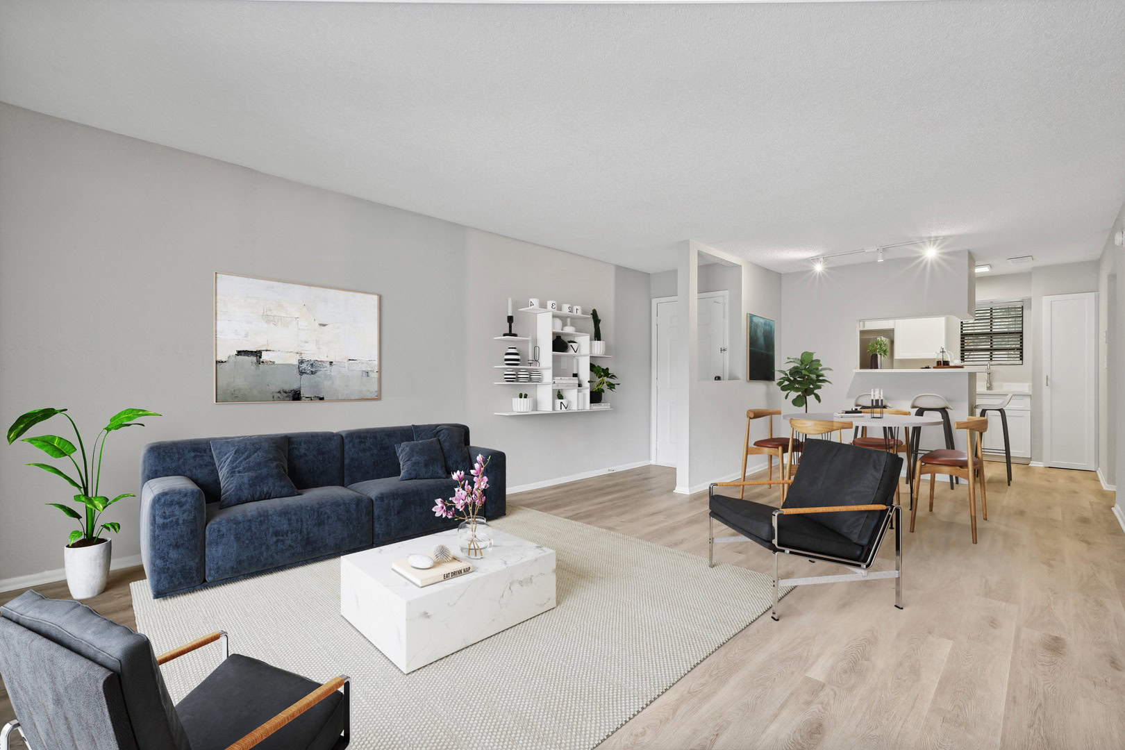 Spacious open concept living room with bright natural lighting and plank flooring