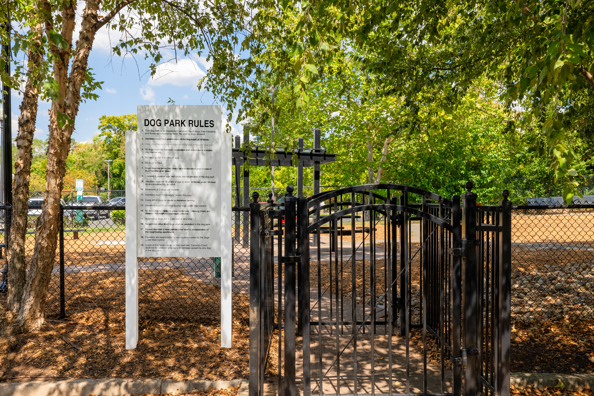 Fenced-in dog par with rules for usage by residents.