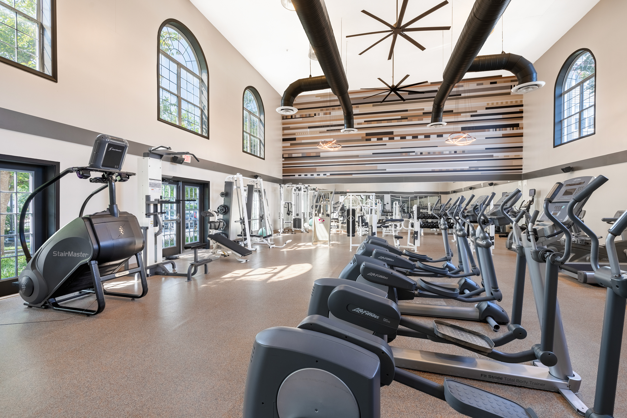 Fitness center with abundant light and treadmills.