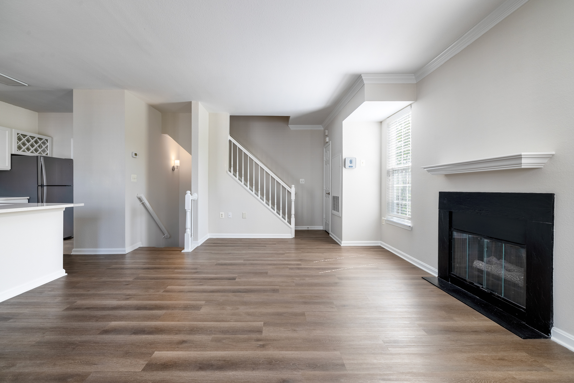 Open layout of a townhome apartment with fireplace and stairs.