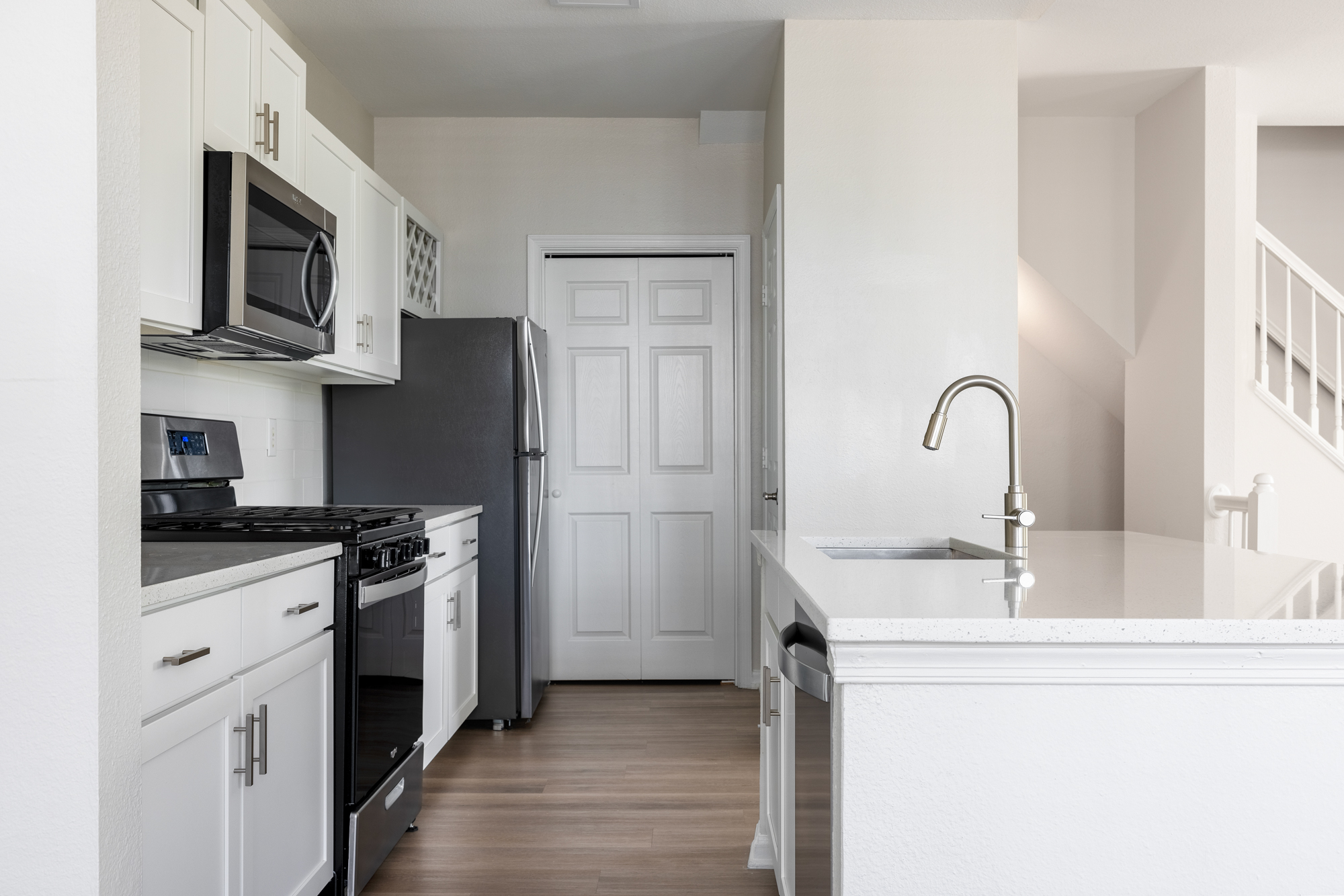 Kitchen with plank-style flooring and stainless appliances.