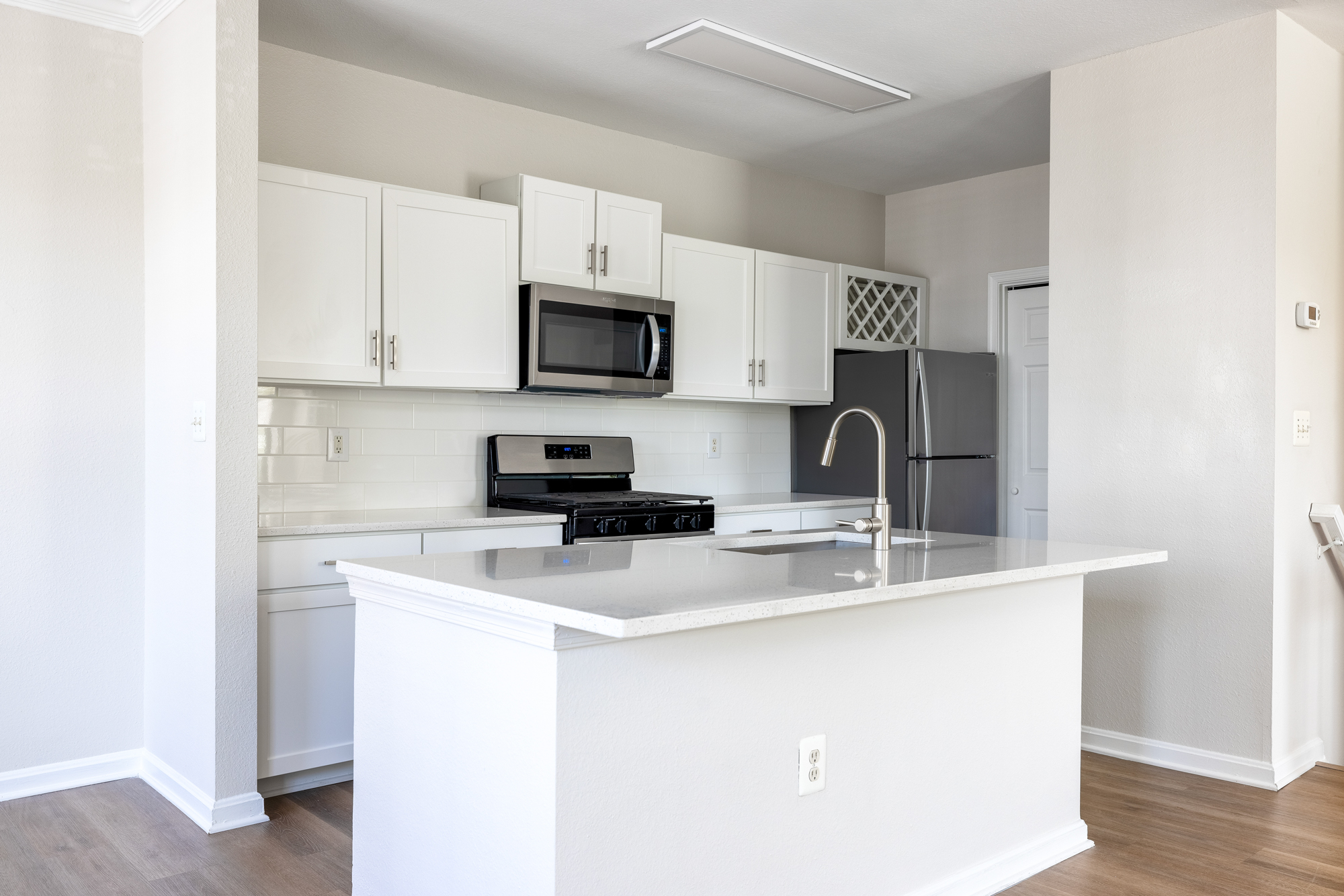 Townhome kitchen with shaker-style cabinetry and quartz countertops.