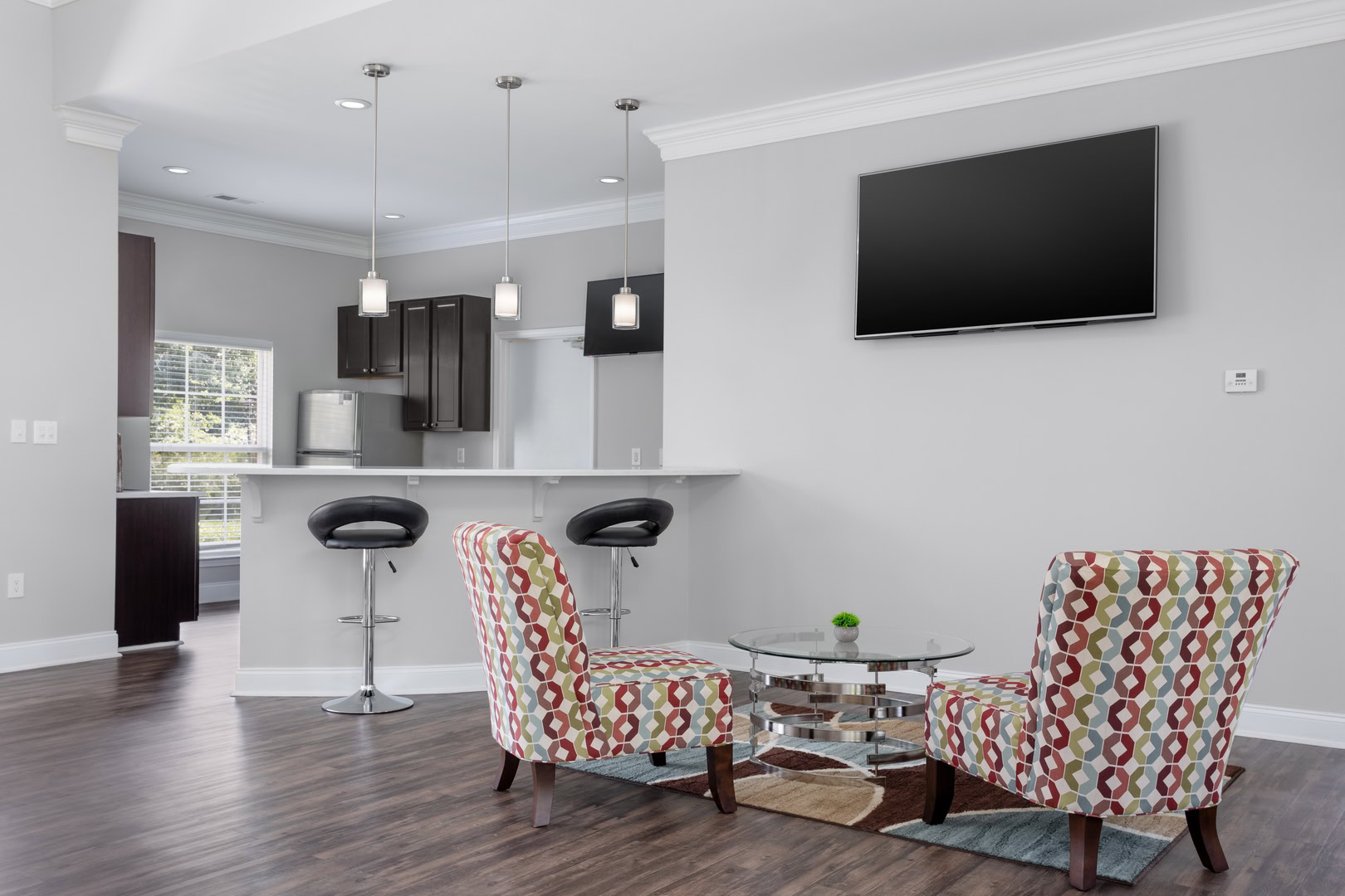 A living room in front of a kitchen peninsula at the Ashford Place apartments in South Charlotte